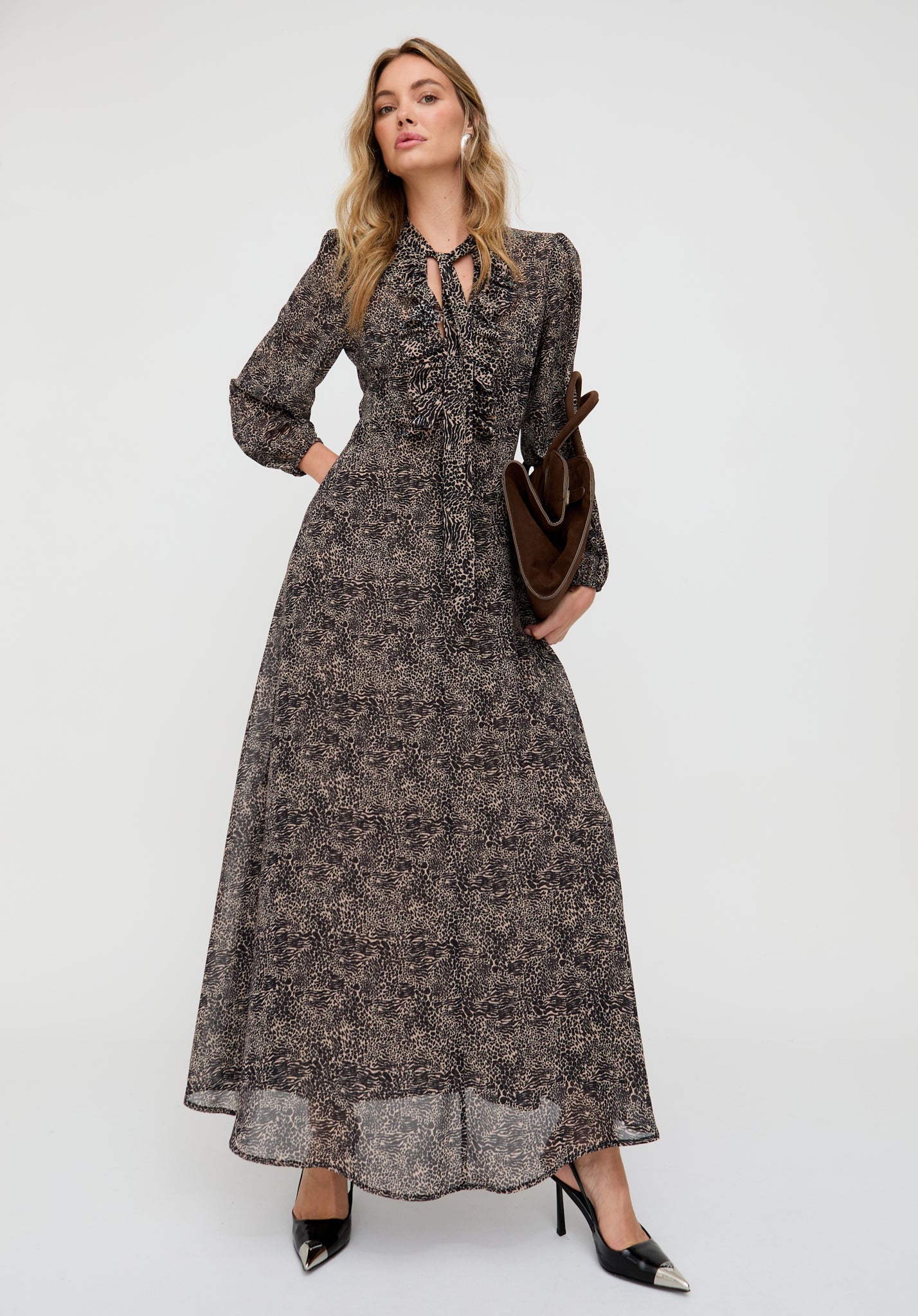 Woman wearing a long floral dress with a plain background