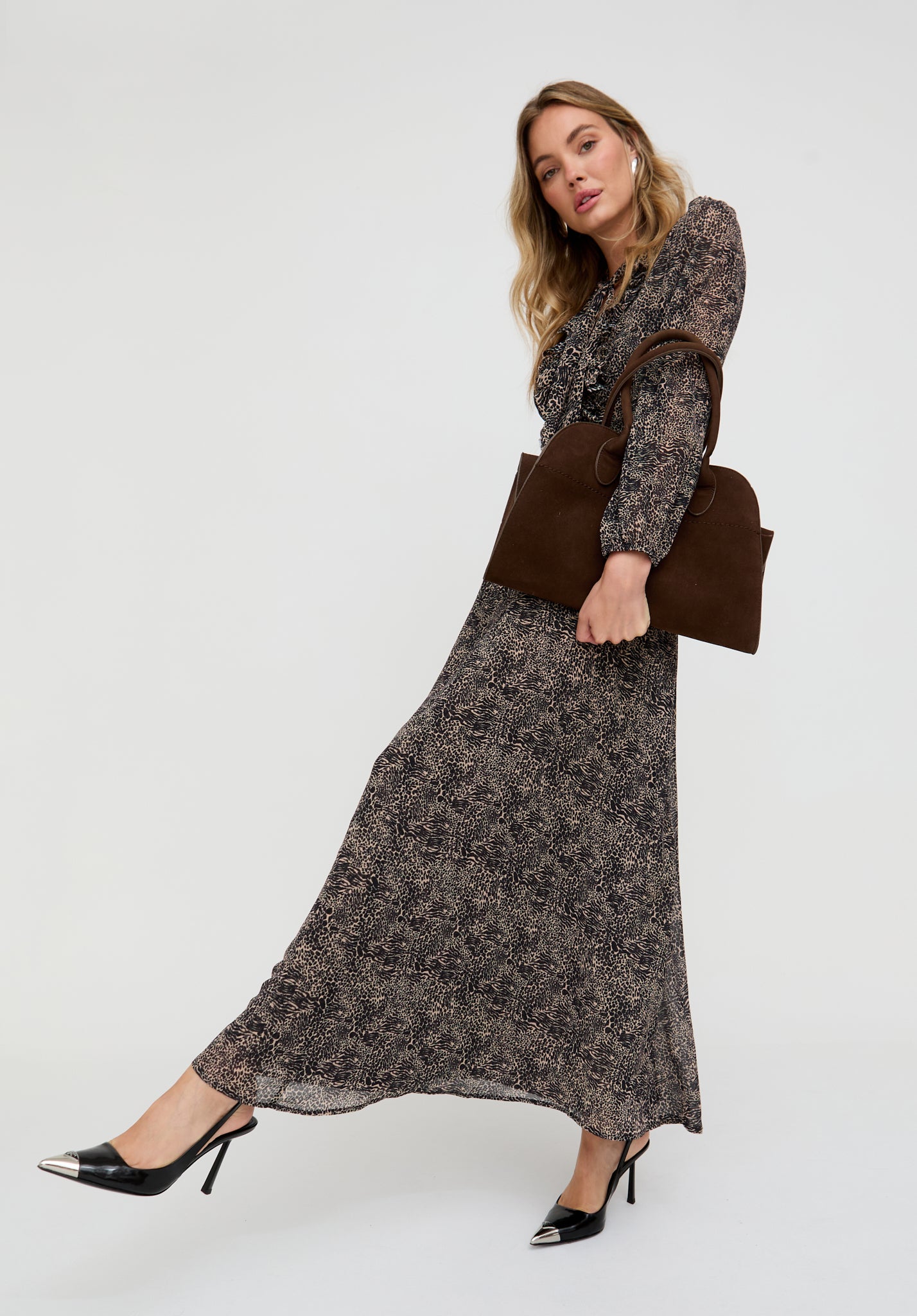 Woman wearing a floral dress and holding a brown bag on a white background