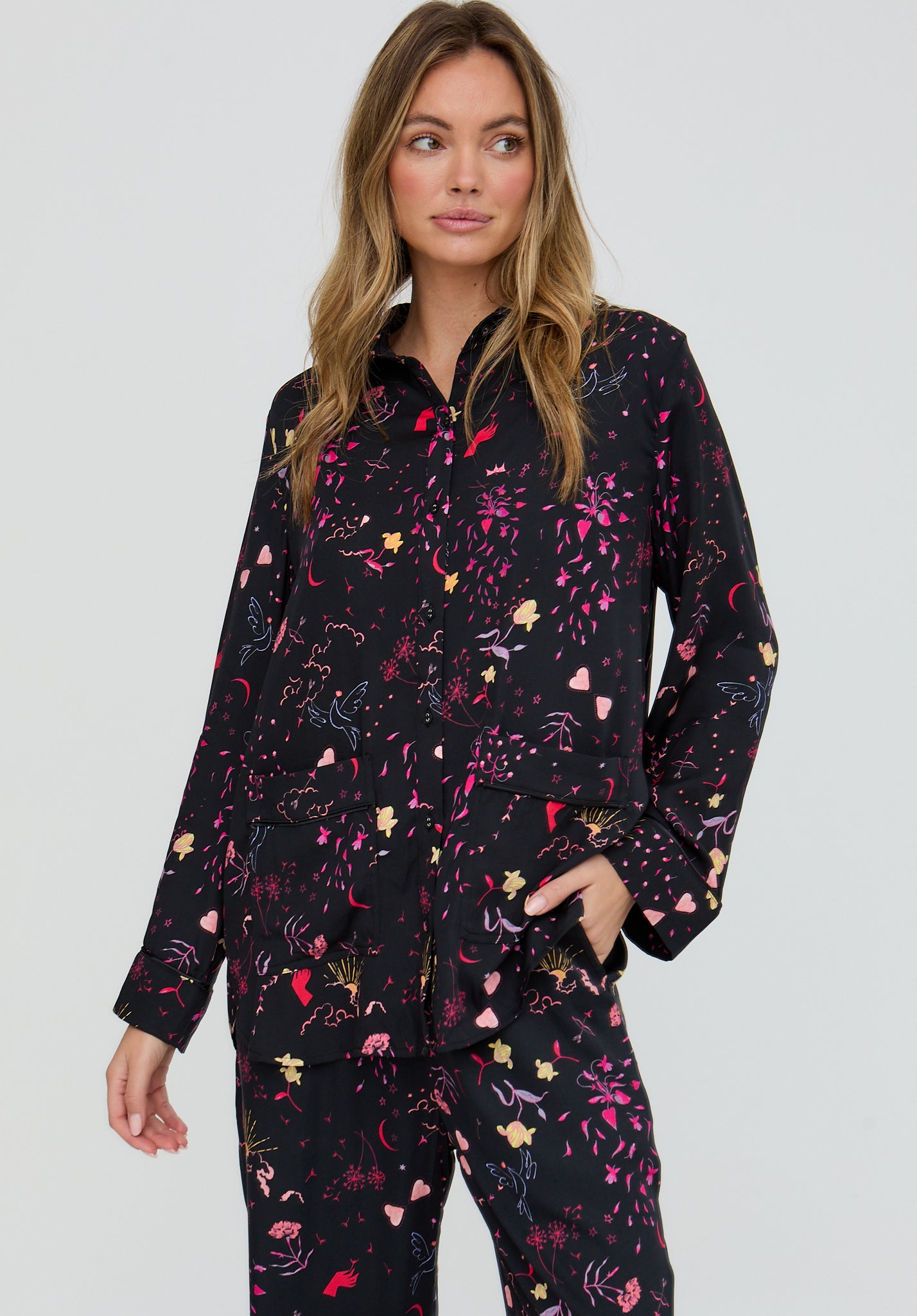 Woman wearing a black floral pajama set on a gray background