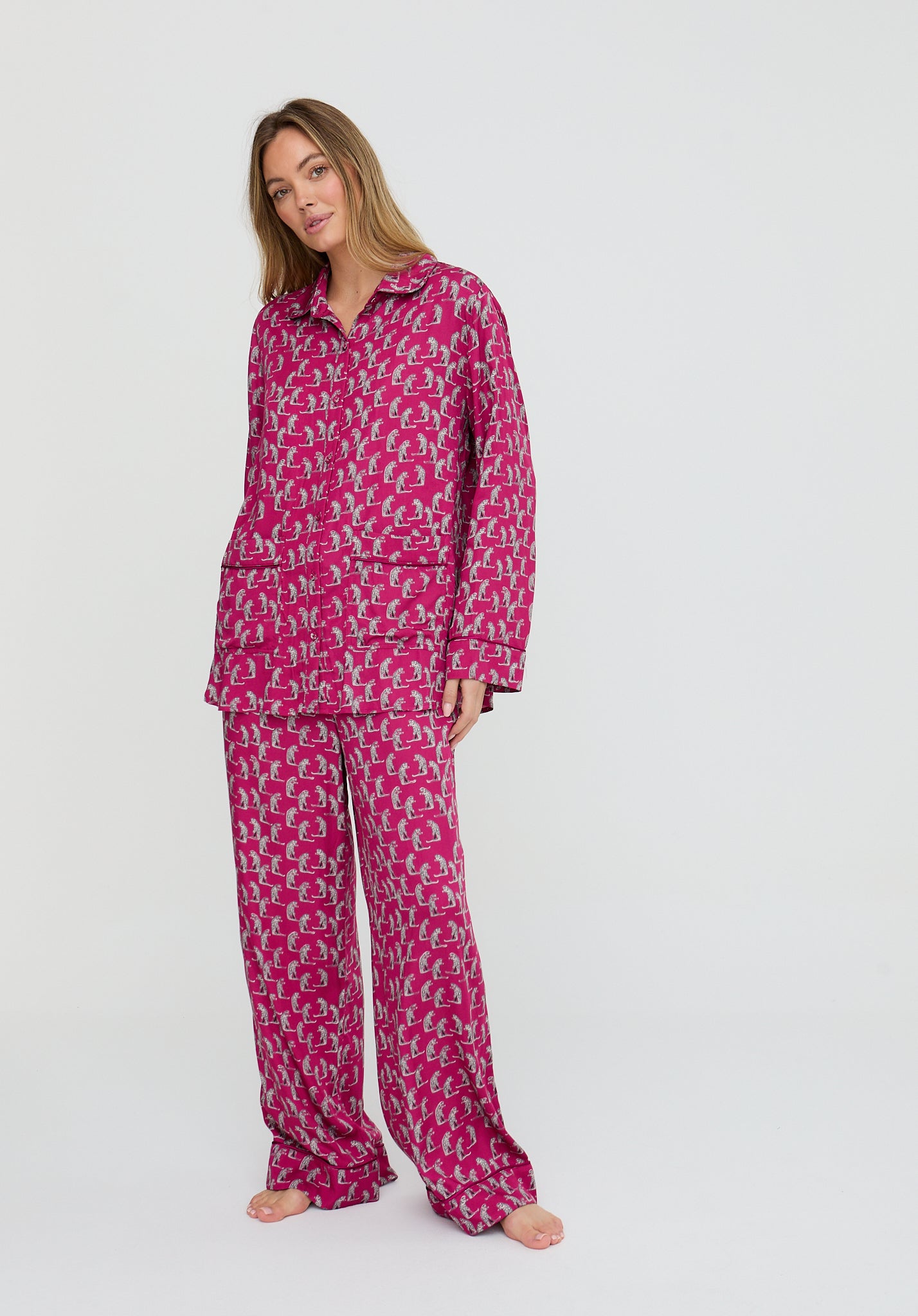 Woman wearing a pink patterned pajama set on a white background