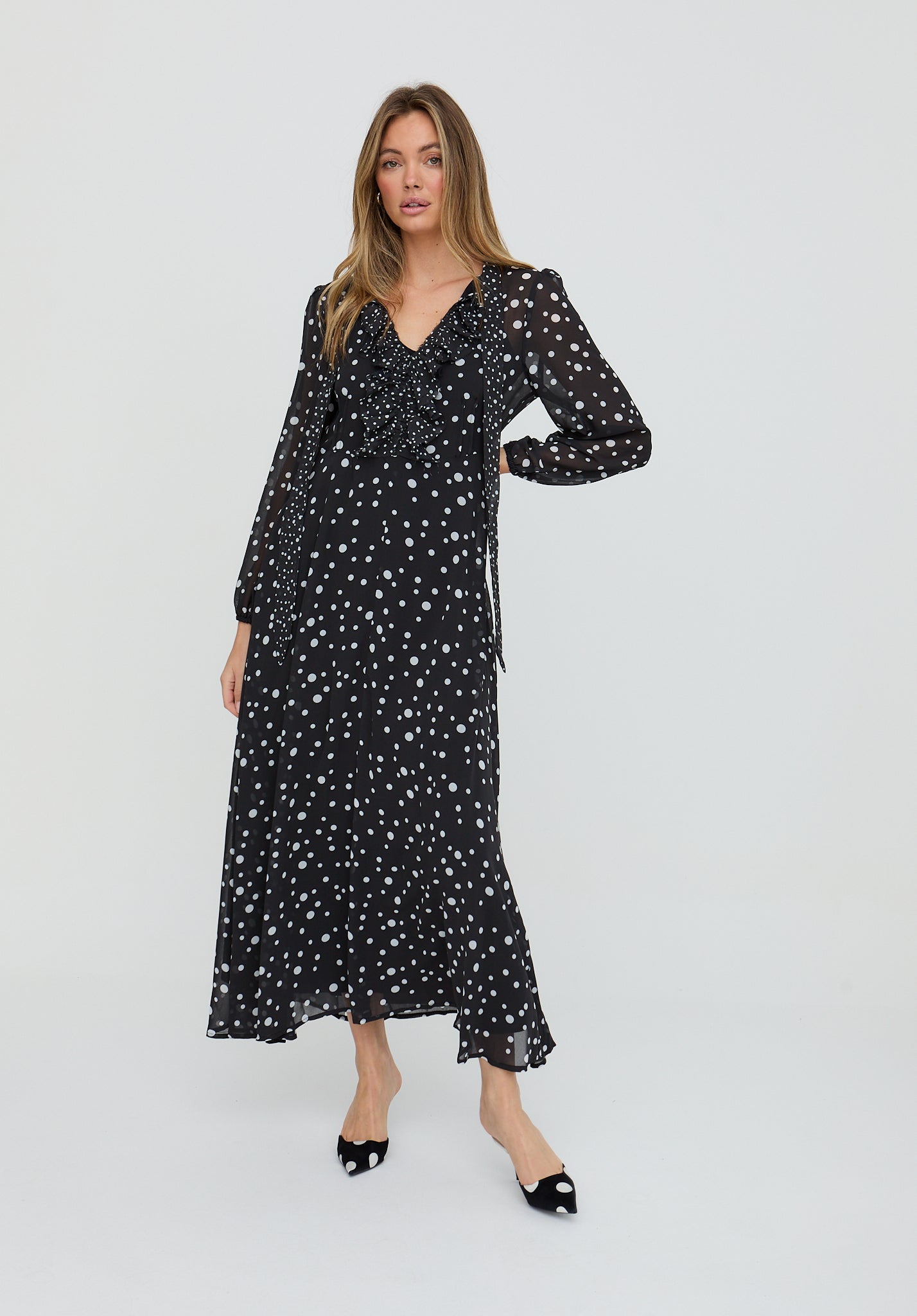 Woman wearing a black dress with white patterns on a white background