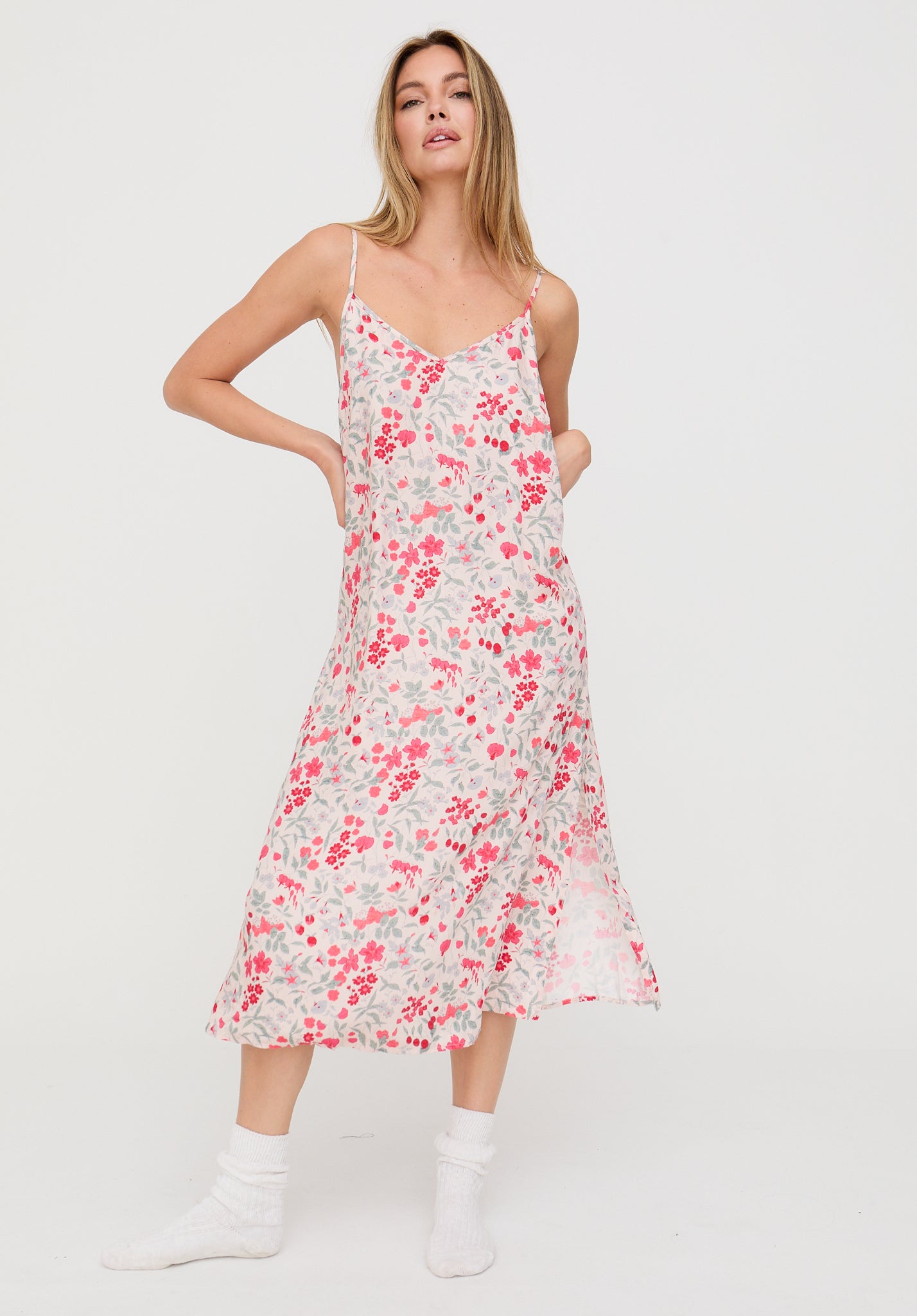 Woman wearing a floral slip dress on a white background