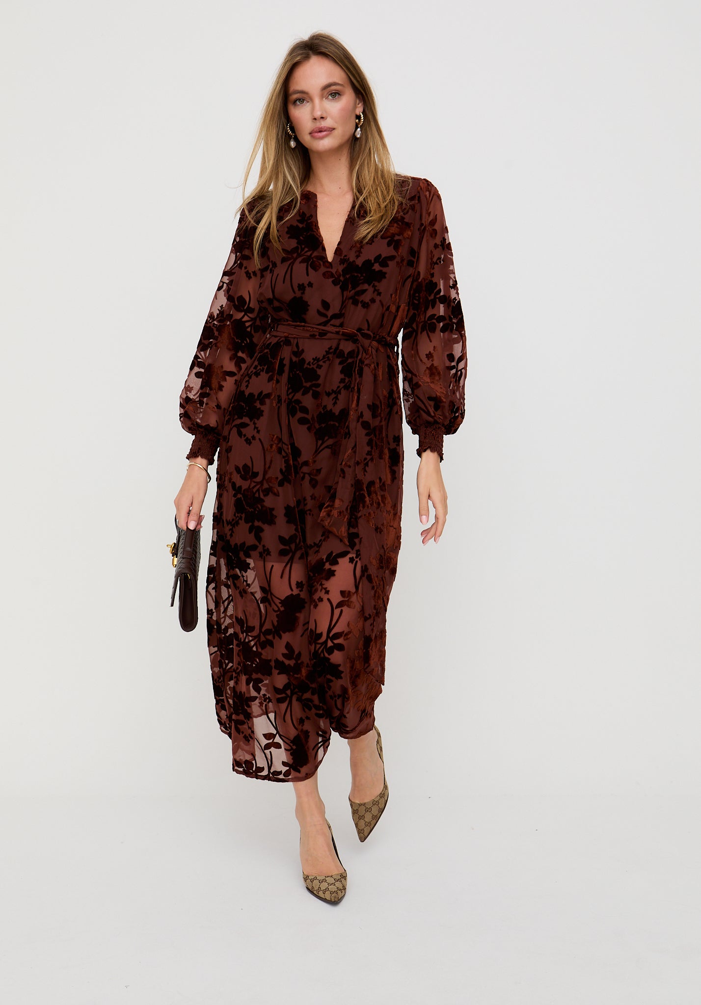 Woman wearing a brown floral dress on a white background