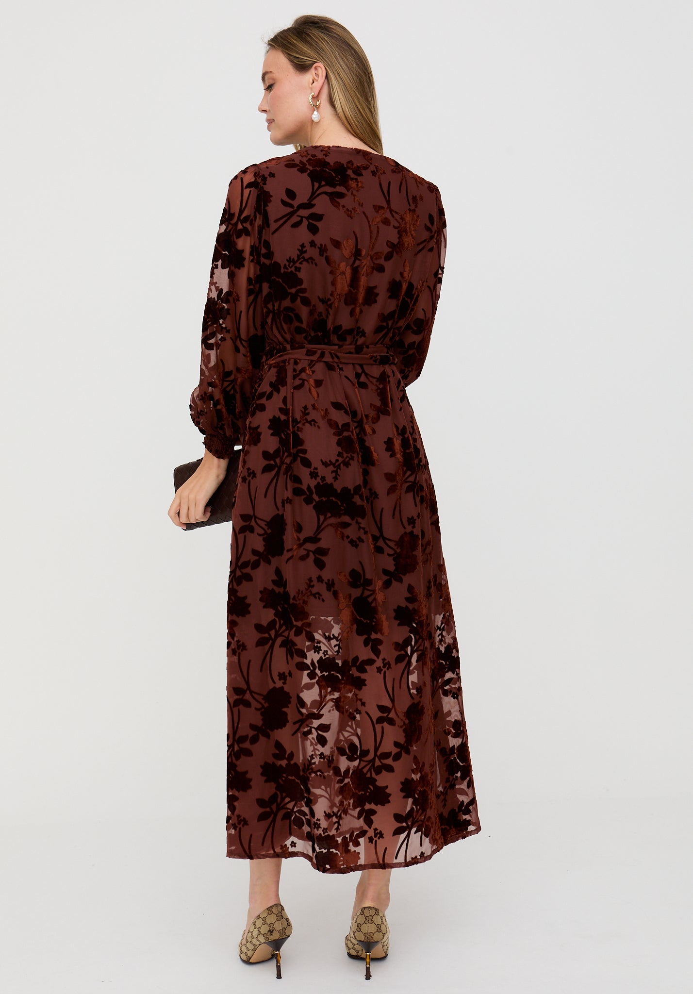 Woman wearing a brown floral dress on a white background