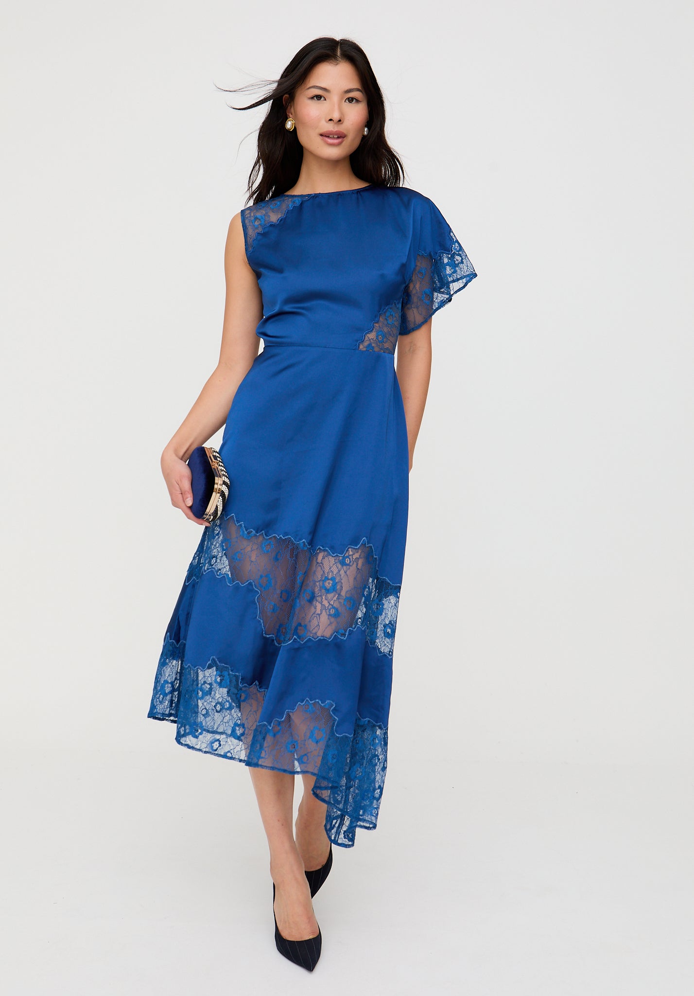 Woman wearing a blue dress with lace details on a white background