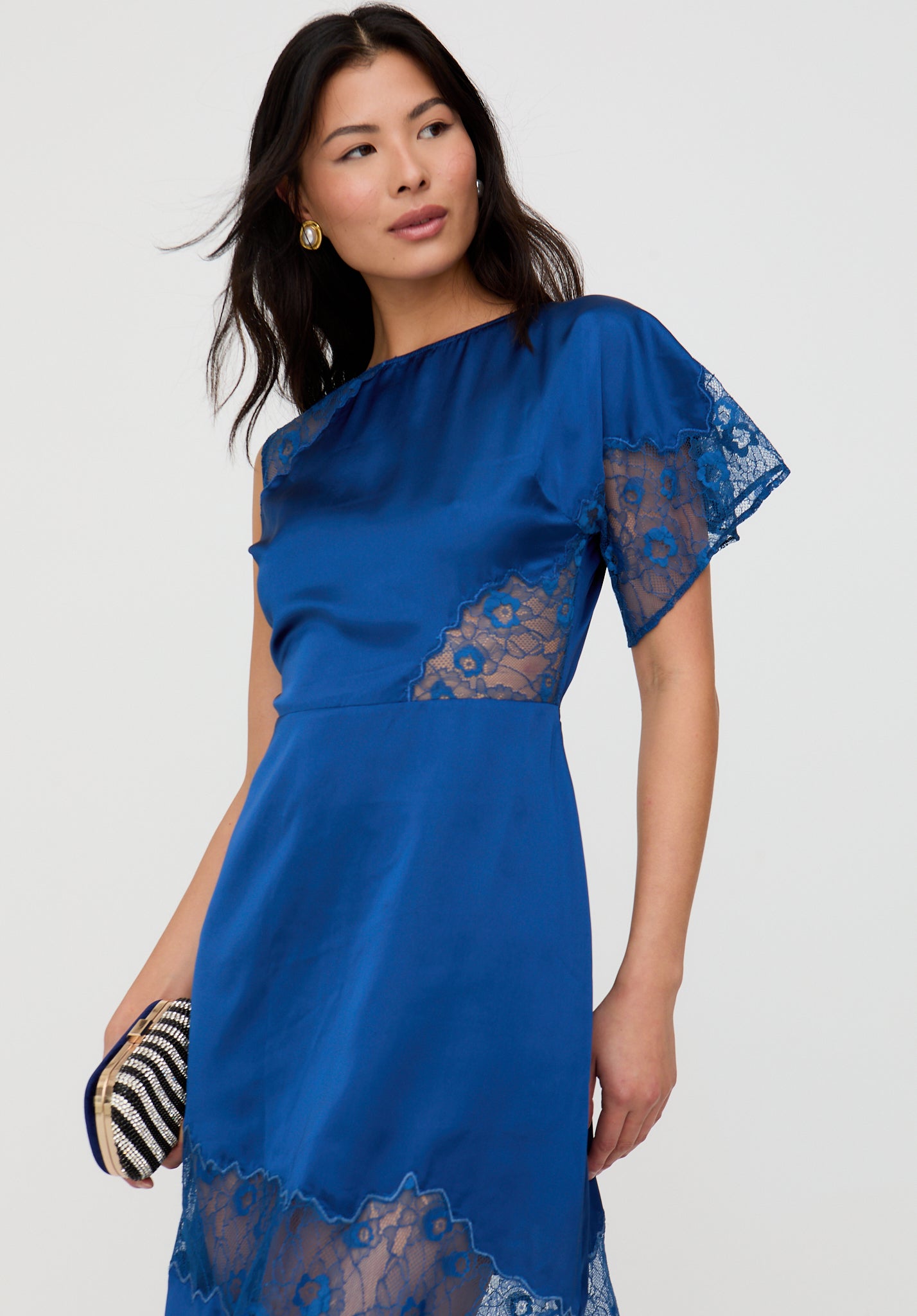 Woman wearing a blue dress with lace details on a white background