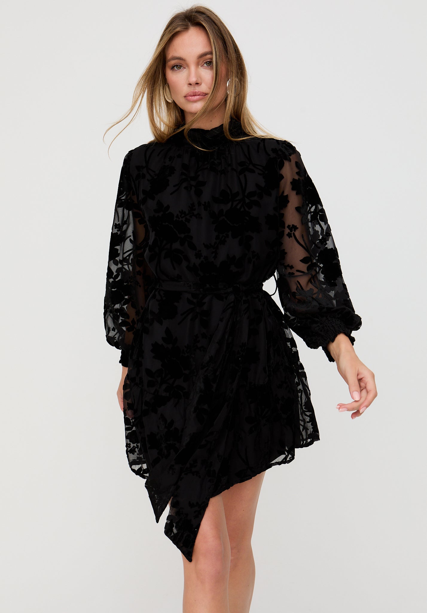 Woman wearing a black lace dress on a white background