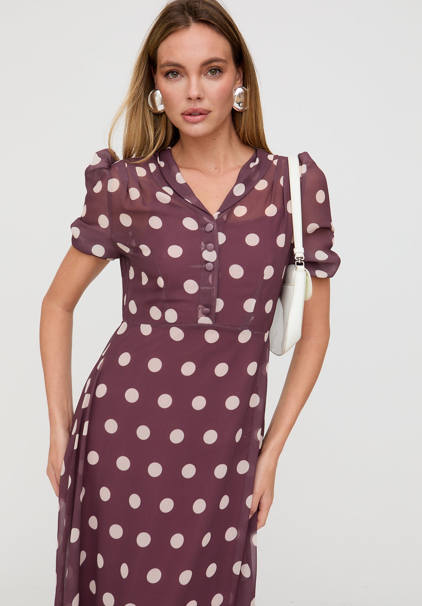 Woman wearing a polka dot dress with a plain background