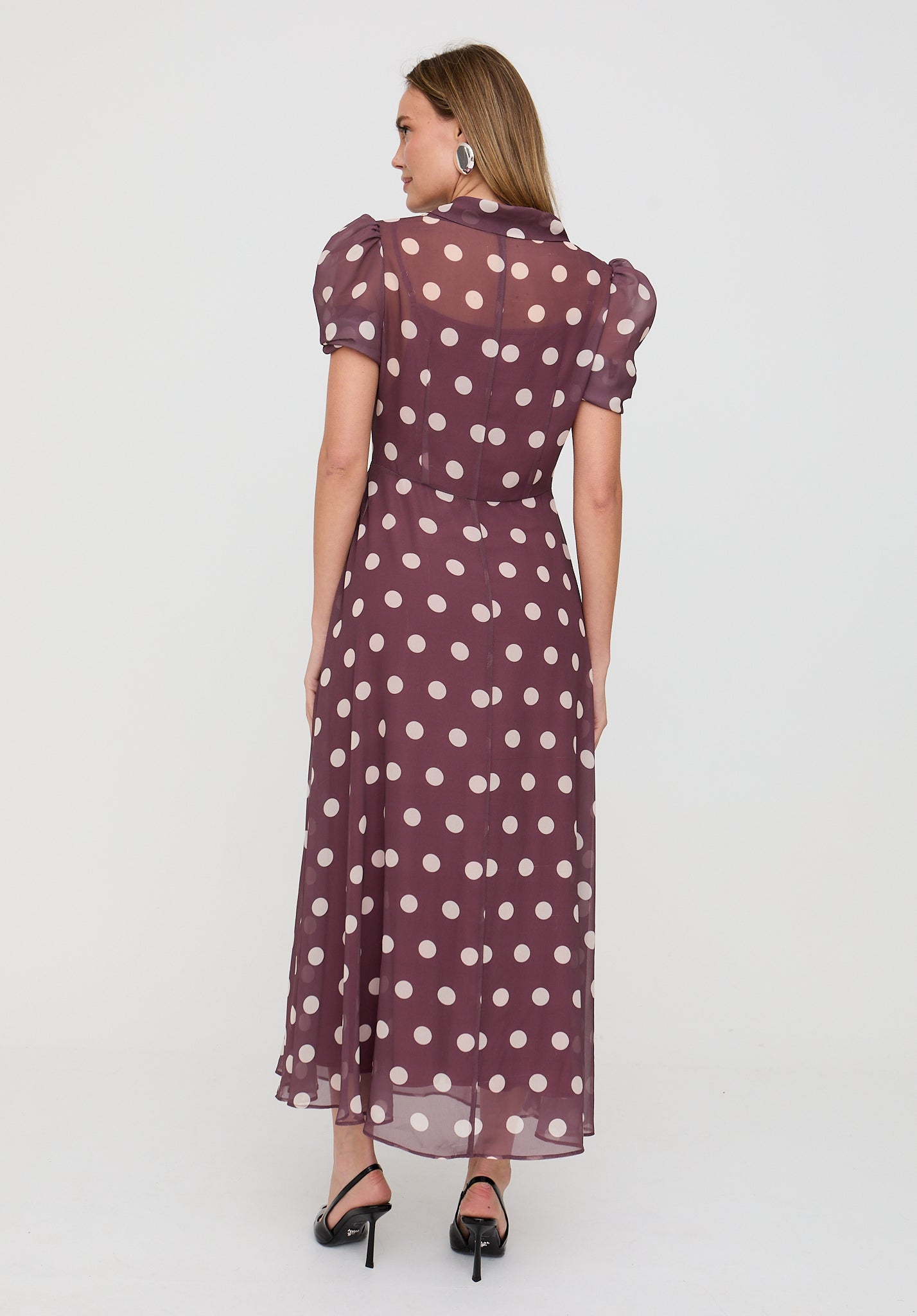 Woman wearing a polka dot dress on a white background