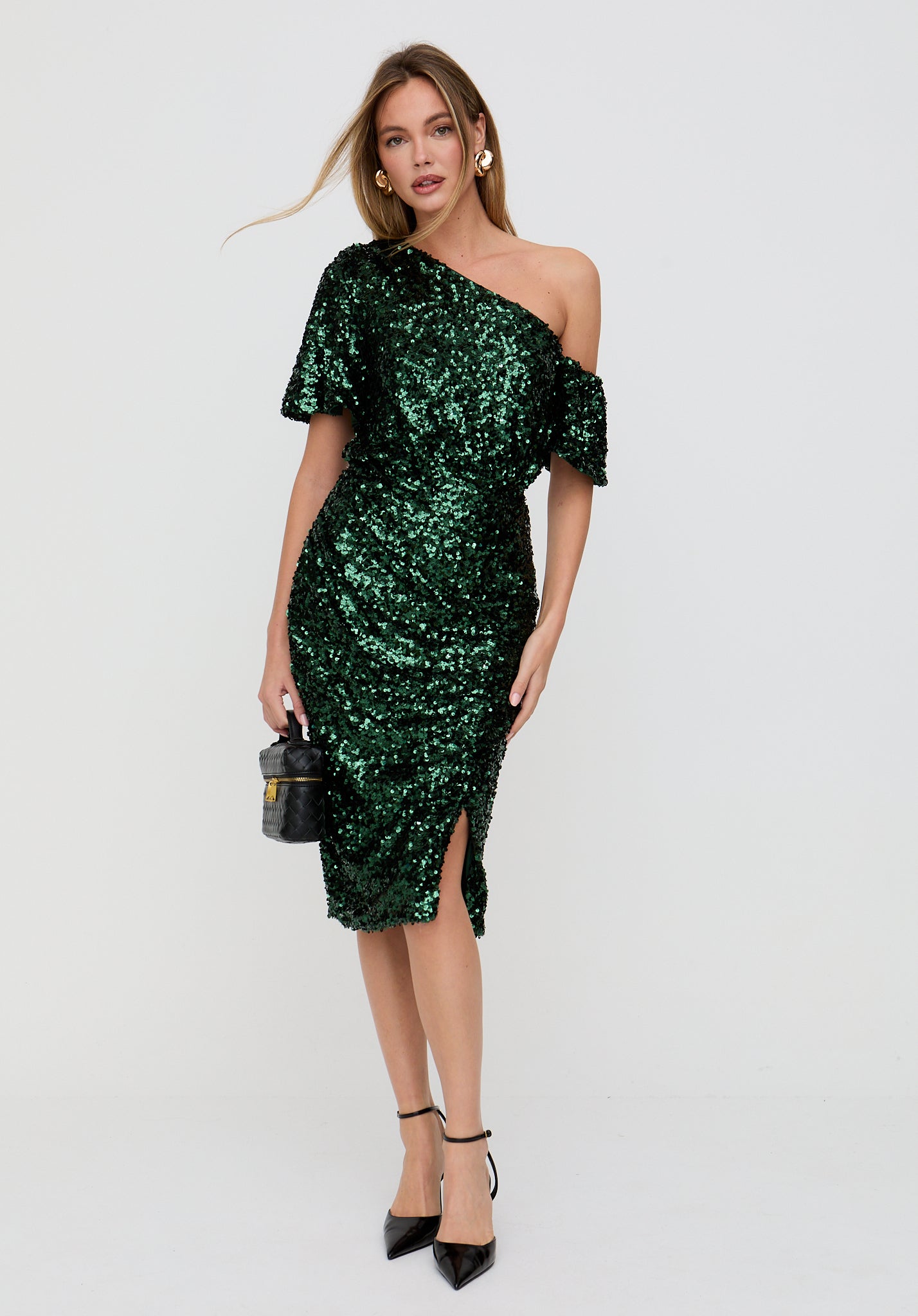 Woman wearing a green sequin dress on a white background