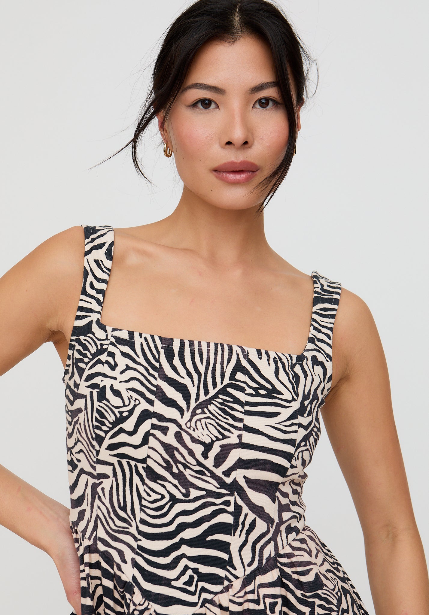 Woman wearing a zebra print dress against a plain background