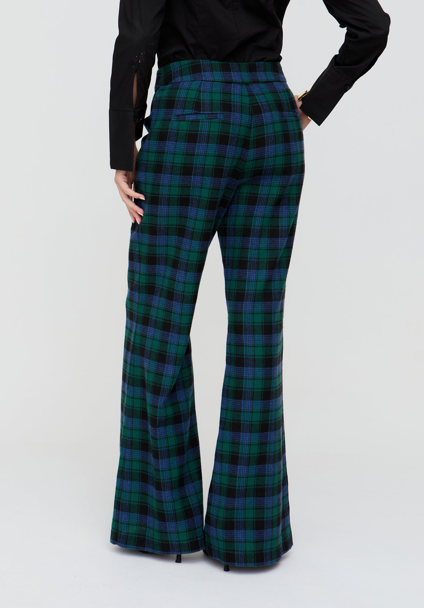 Green and blue plaid flared pants worn by a person on a white background