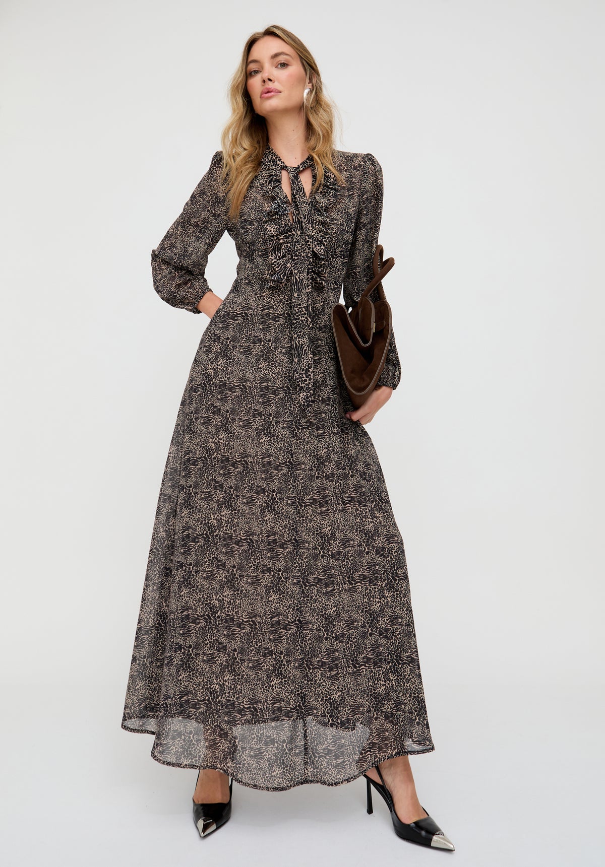 Woman wearing a long floral dress with a plain background