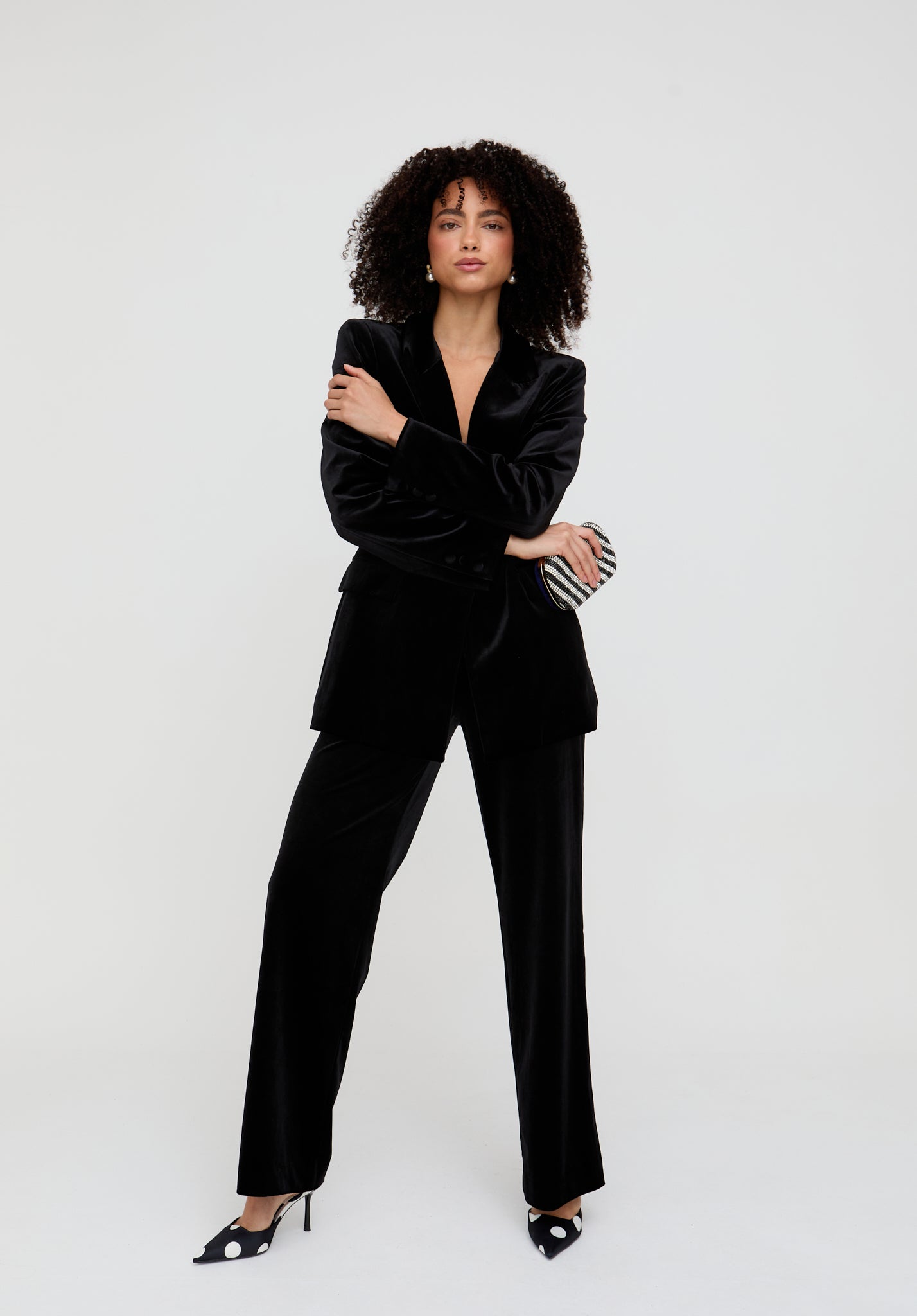 Woman wearing a black suit standing against a white background