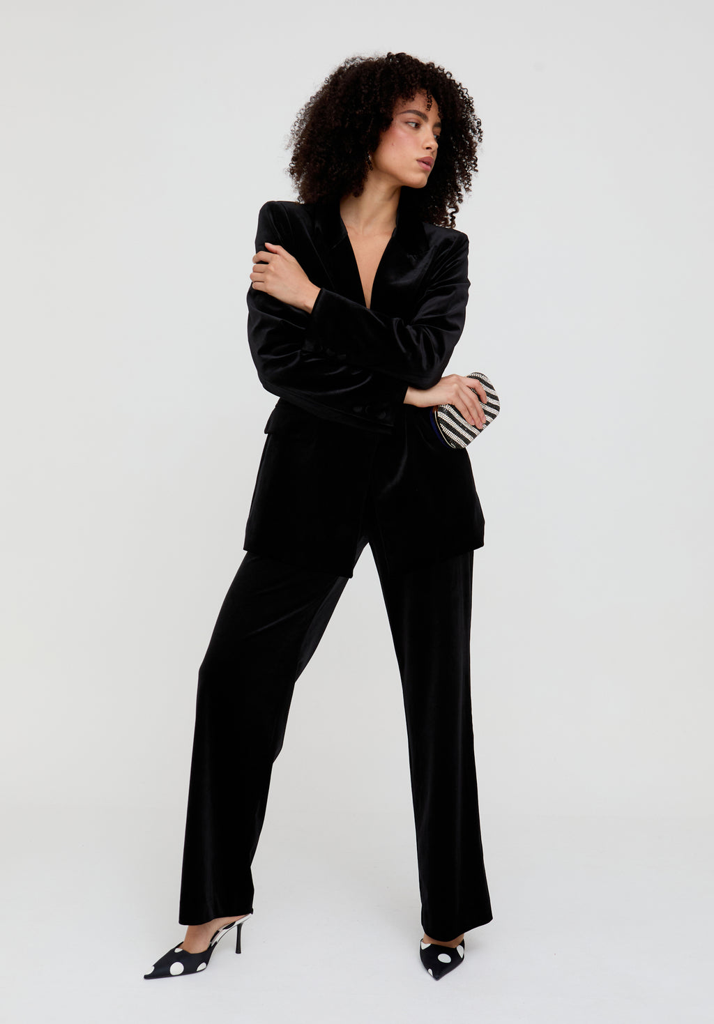 Woman wearing a black velvet suit against a white background