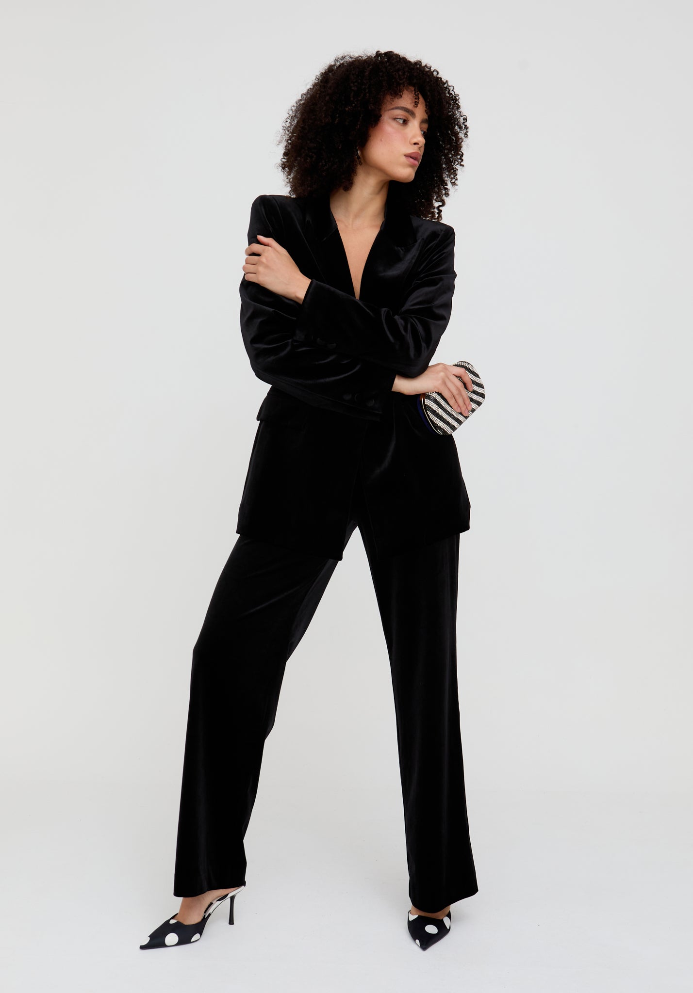 Woman wearing a black velvet suit against a white background