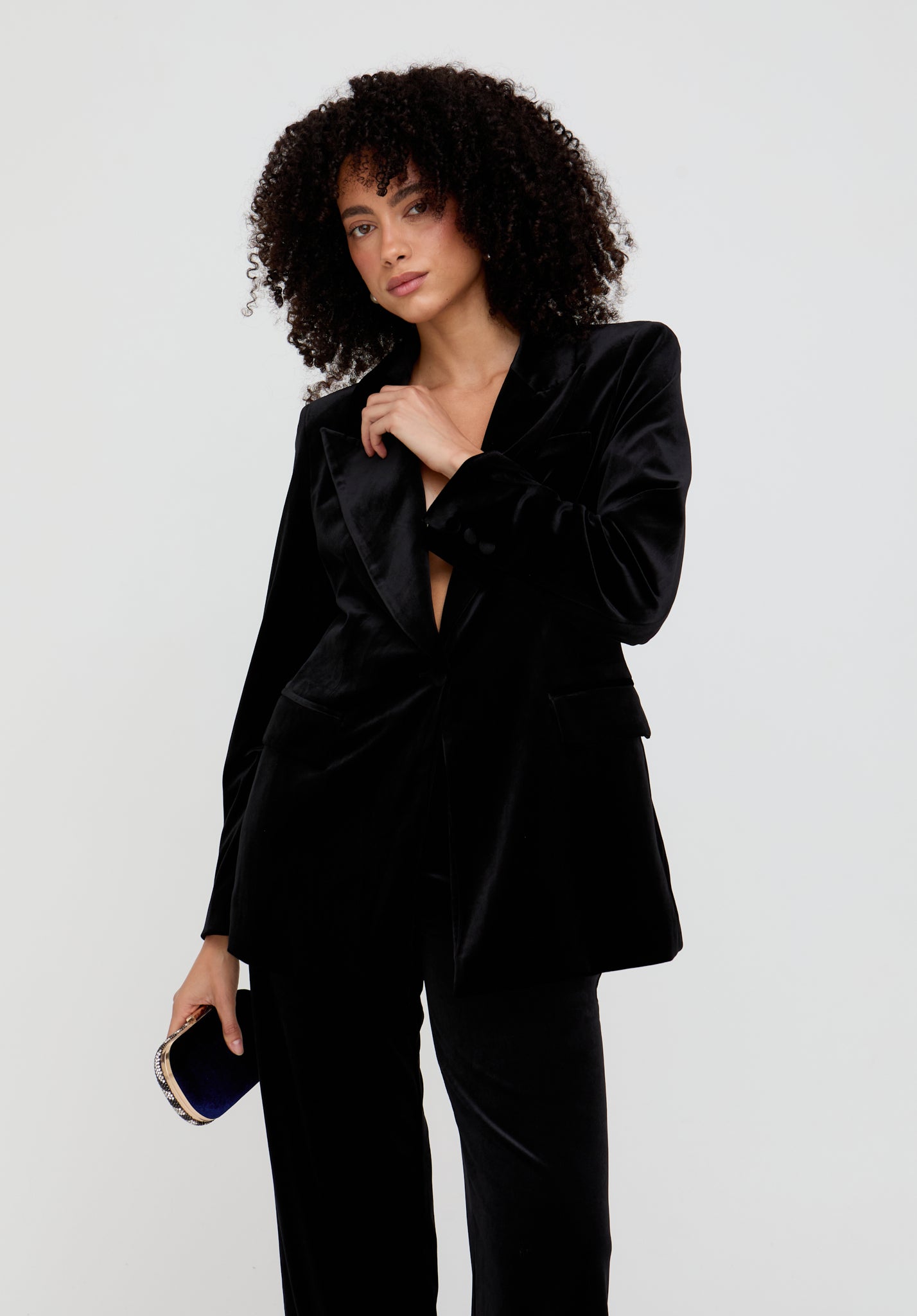 Woman wearing a black suit against a white background