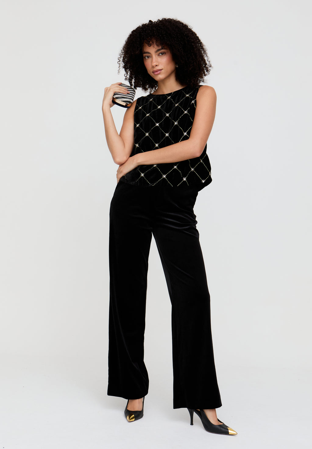 Woman wearing a black quilted top and pants on a white background