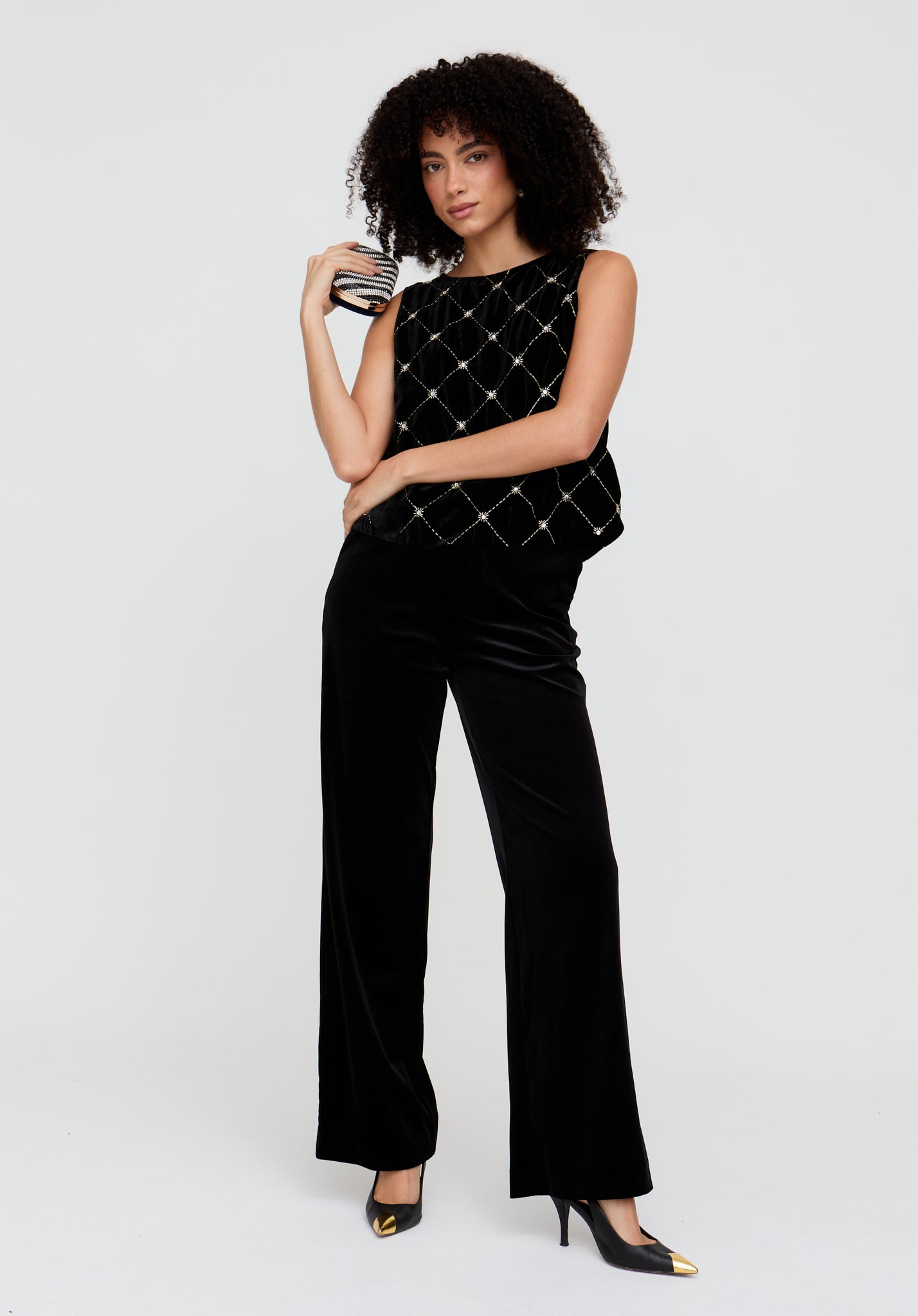 Woman wearing a black quilted top and pants on a white background