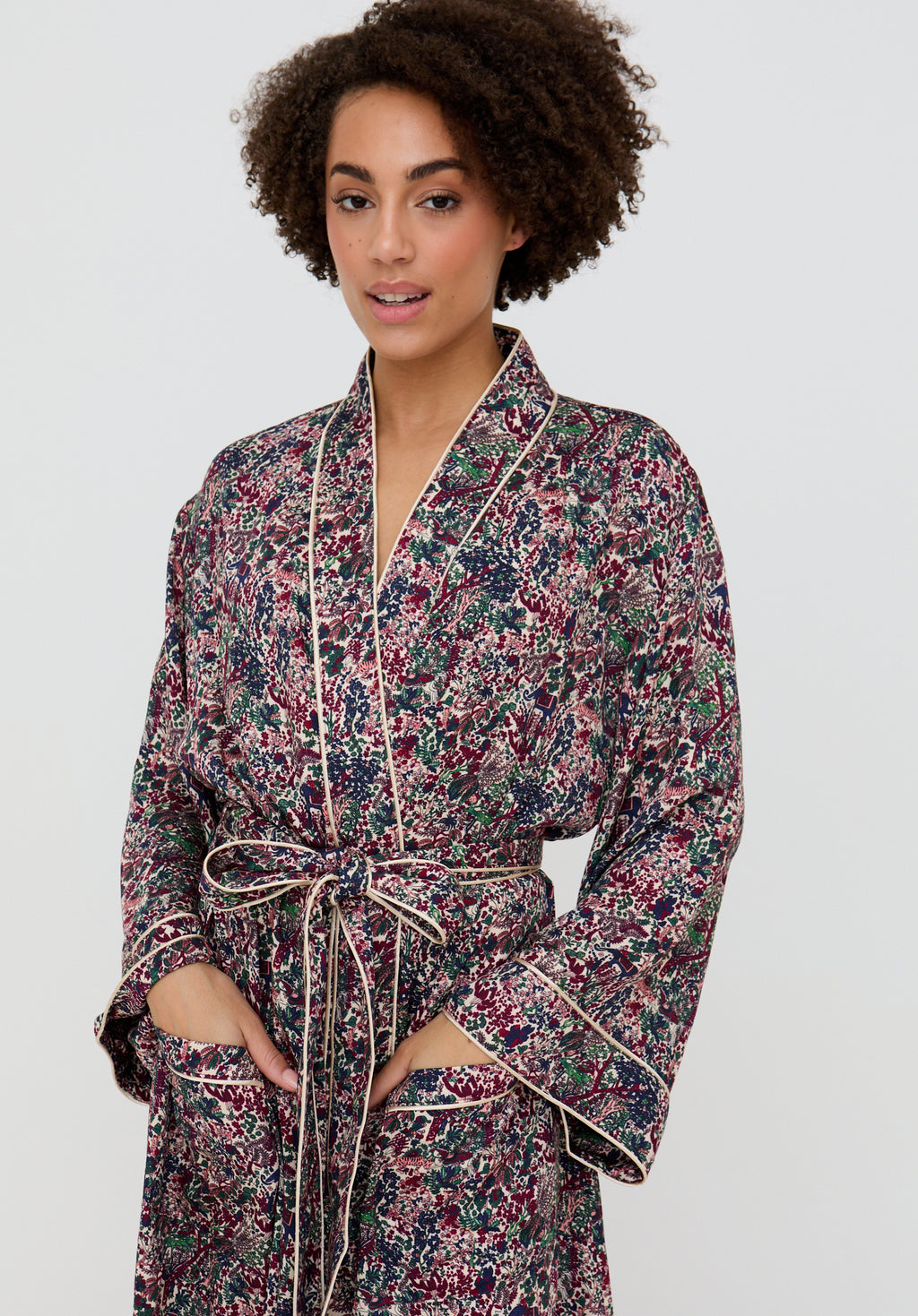 Woman wearing a floral robe against a plain background