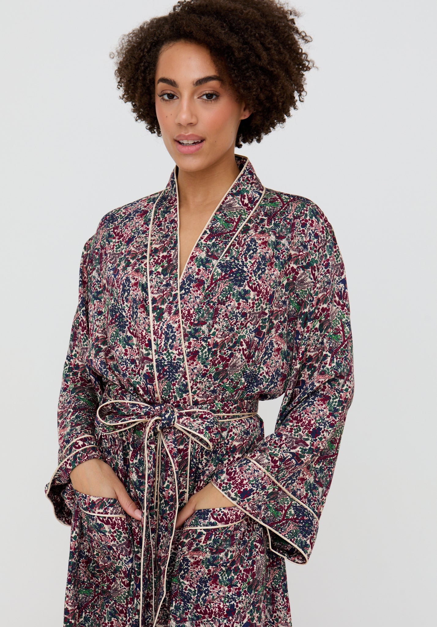 Woman wearing a floral robe against a plain background