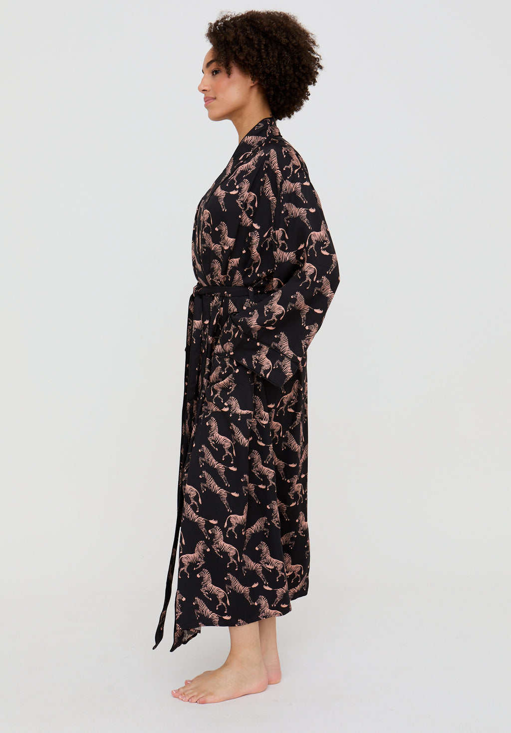 Woman wearing a long, patterned robe on a white background