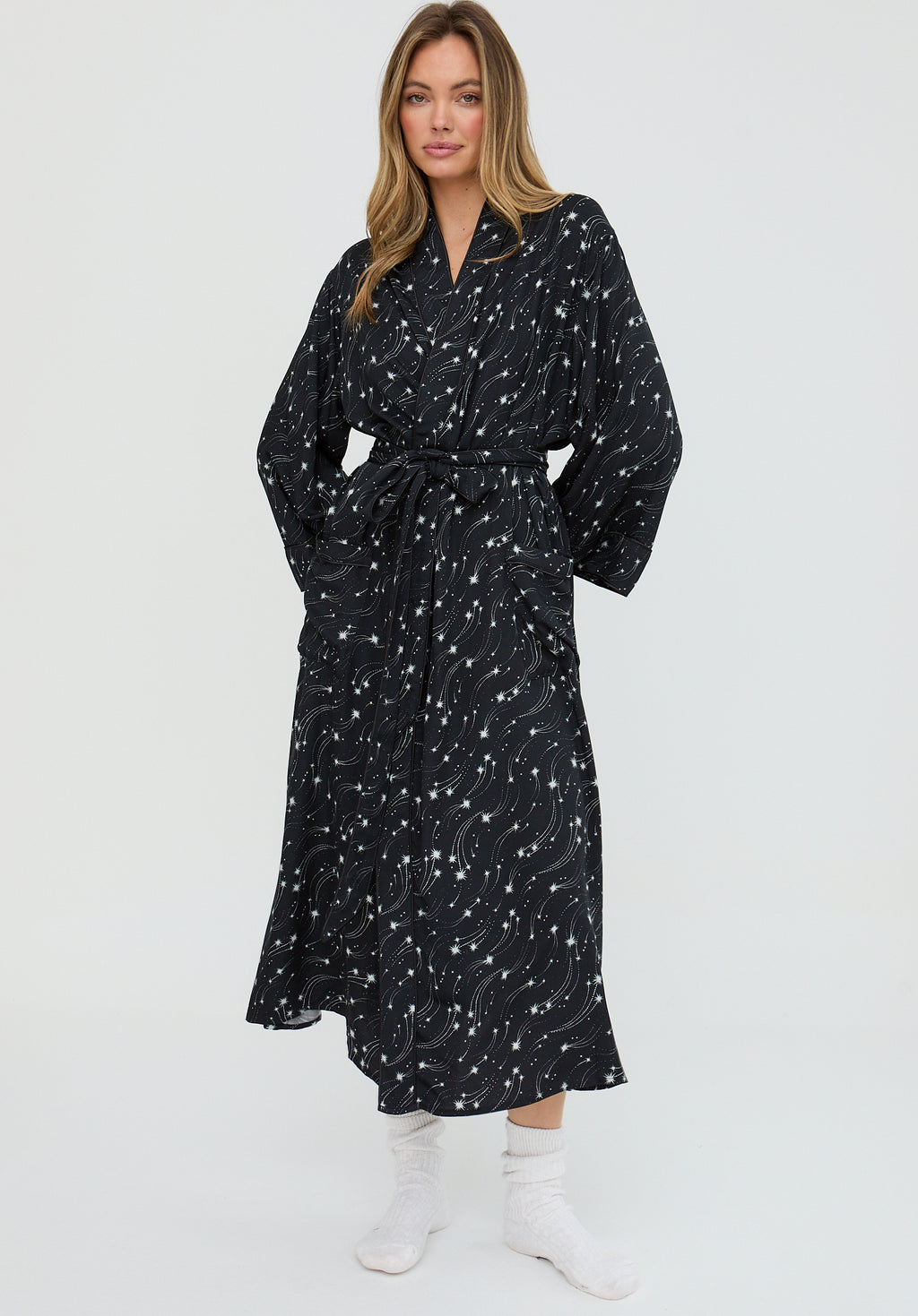 Woman wearing a black patterned dress on a white background