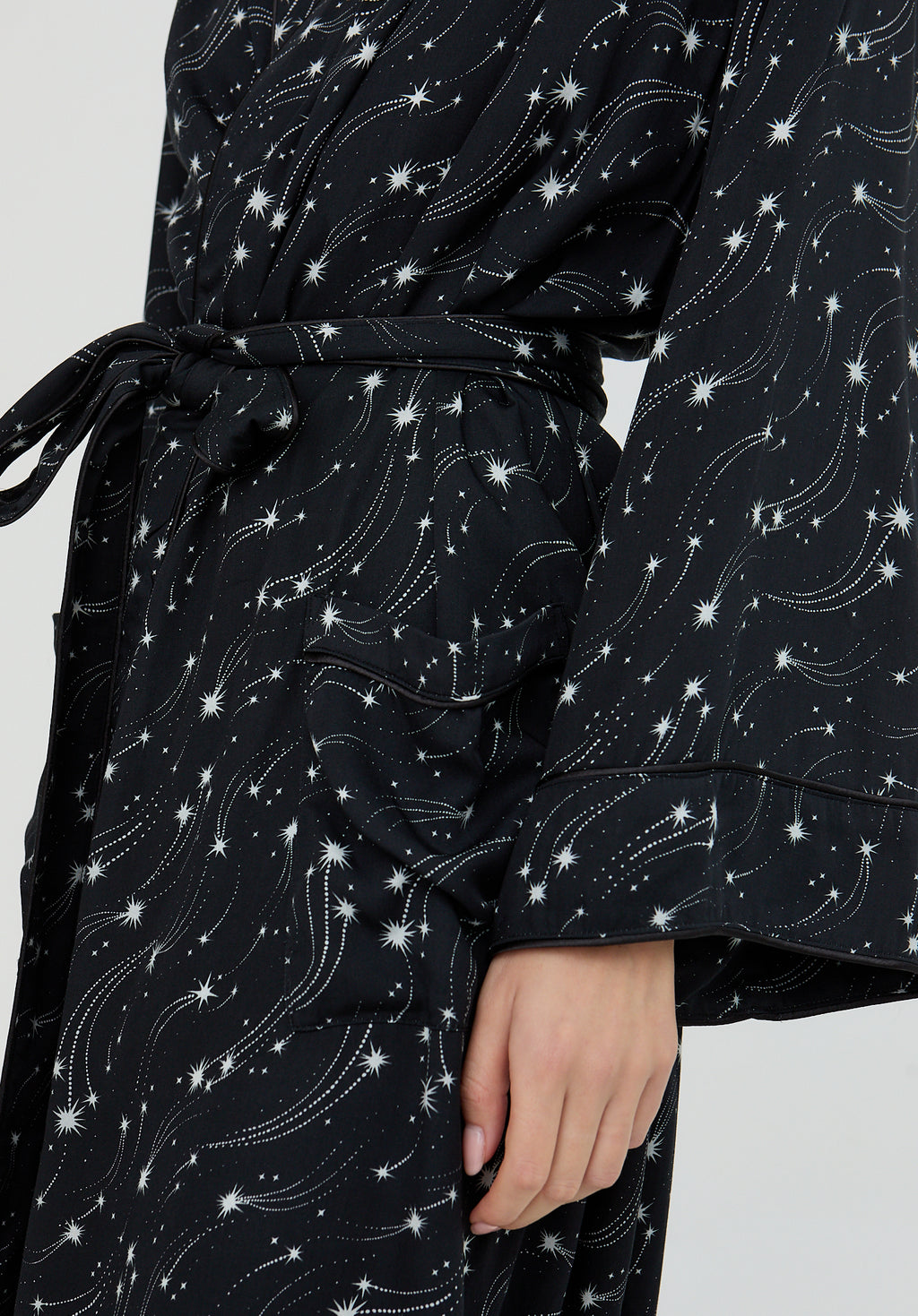 Black robe with white star and constellation pattern on a plain background