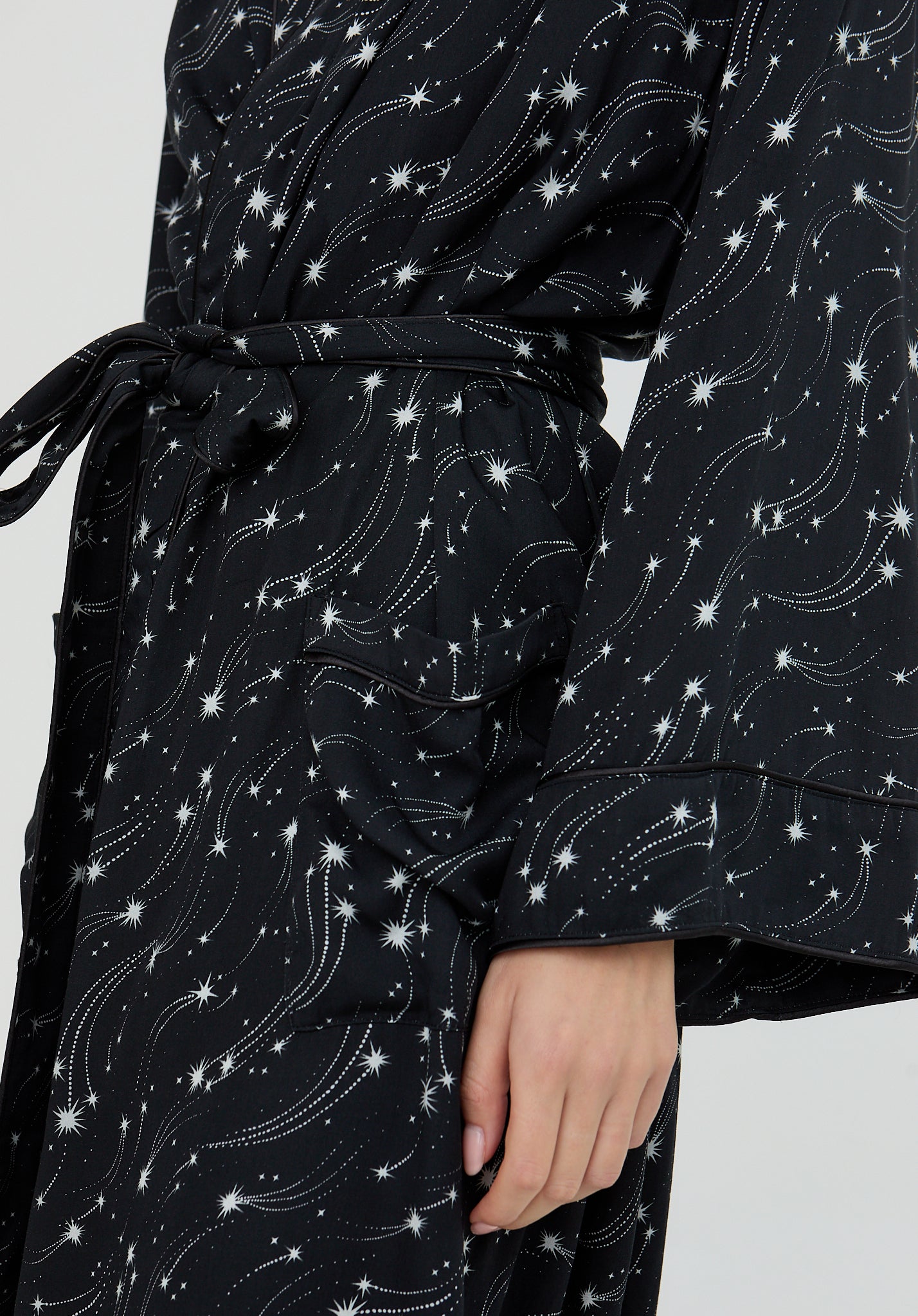 Black robe with white star and constellation pattern on a plain background