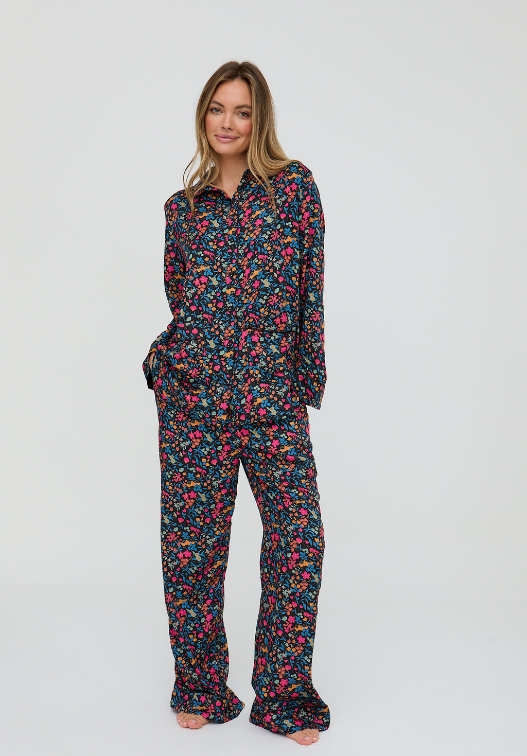 Woman wearing a floral pajama set on a white background