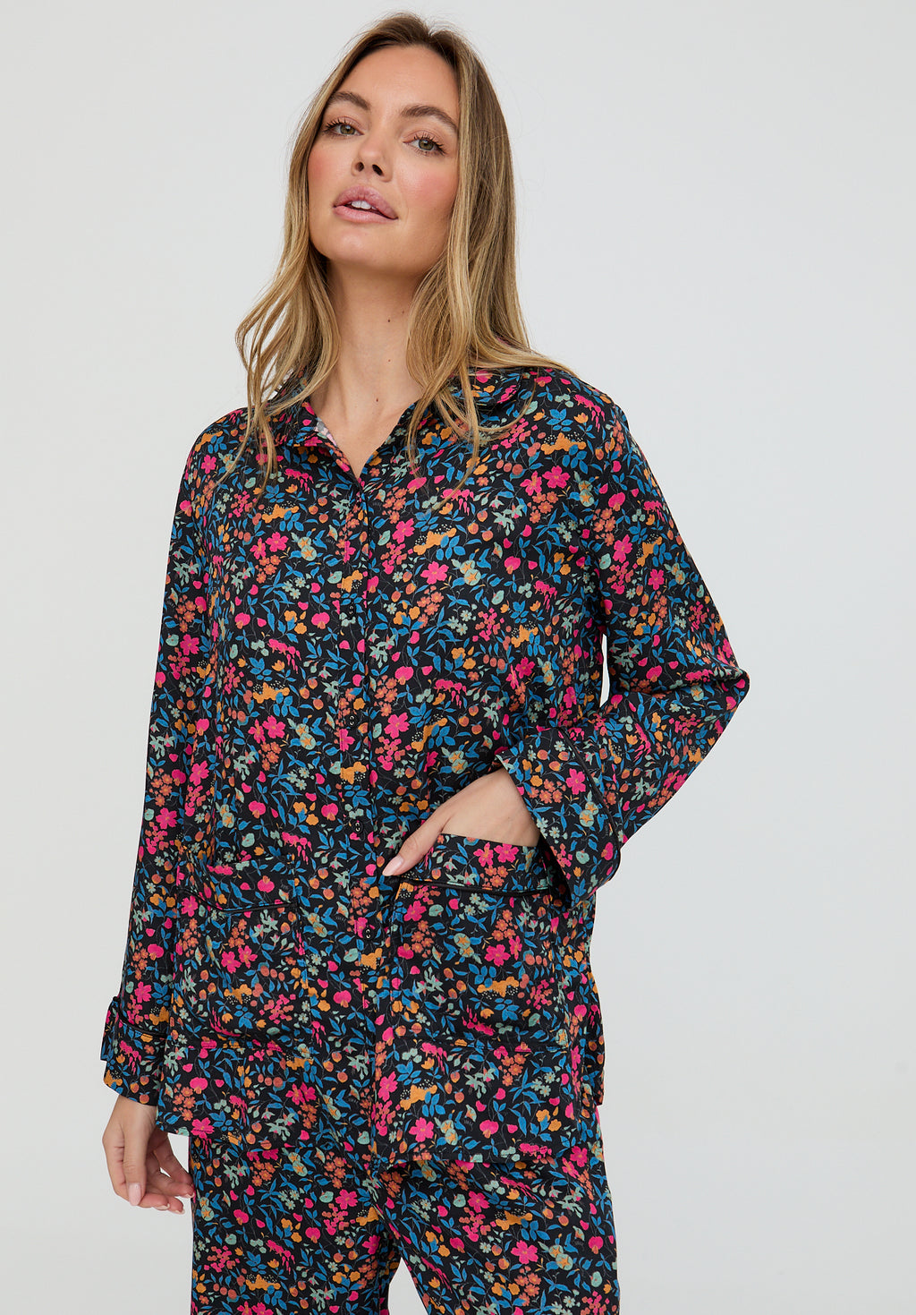 Woman wearing a floral pajama set against a white background