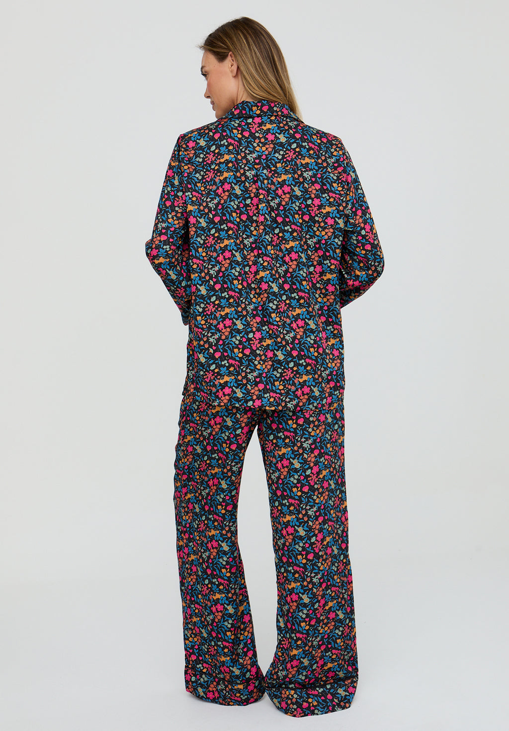 Person wearing a colorful floral pajama set on a white background