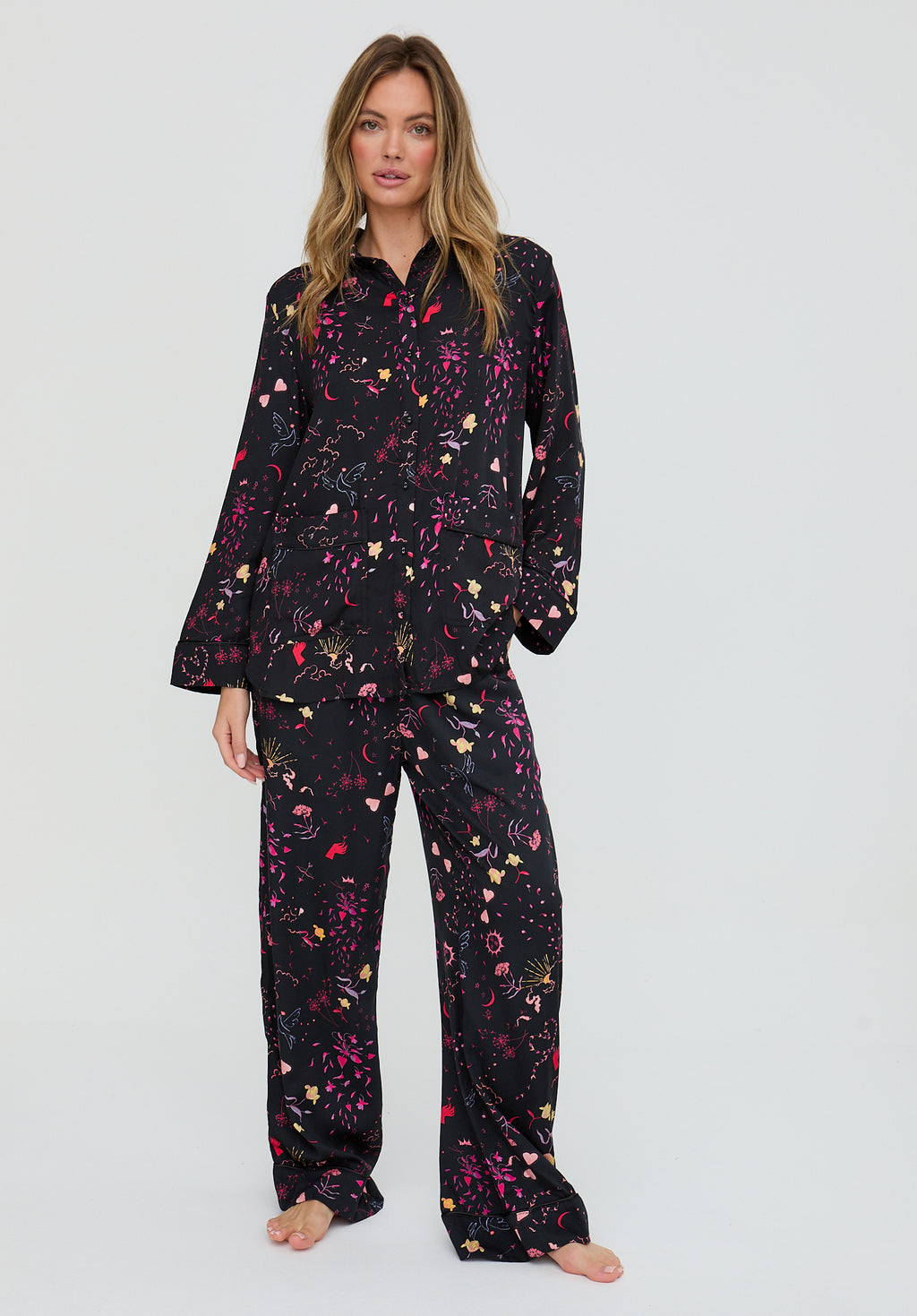Woman wearing a black floral pajama set on a white background