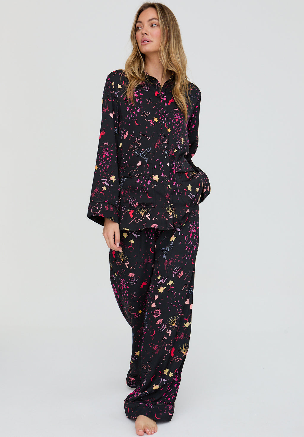 Woman wearing a black floral pajama set on a white background