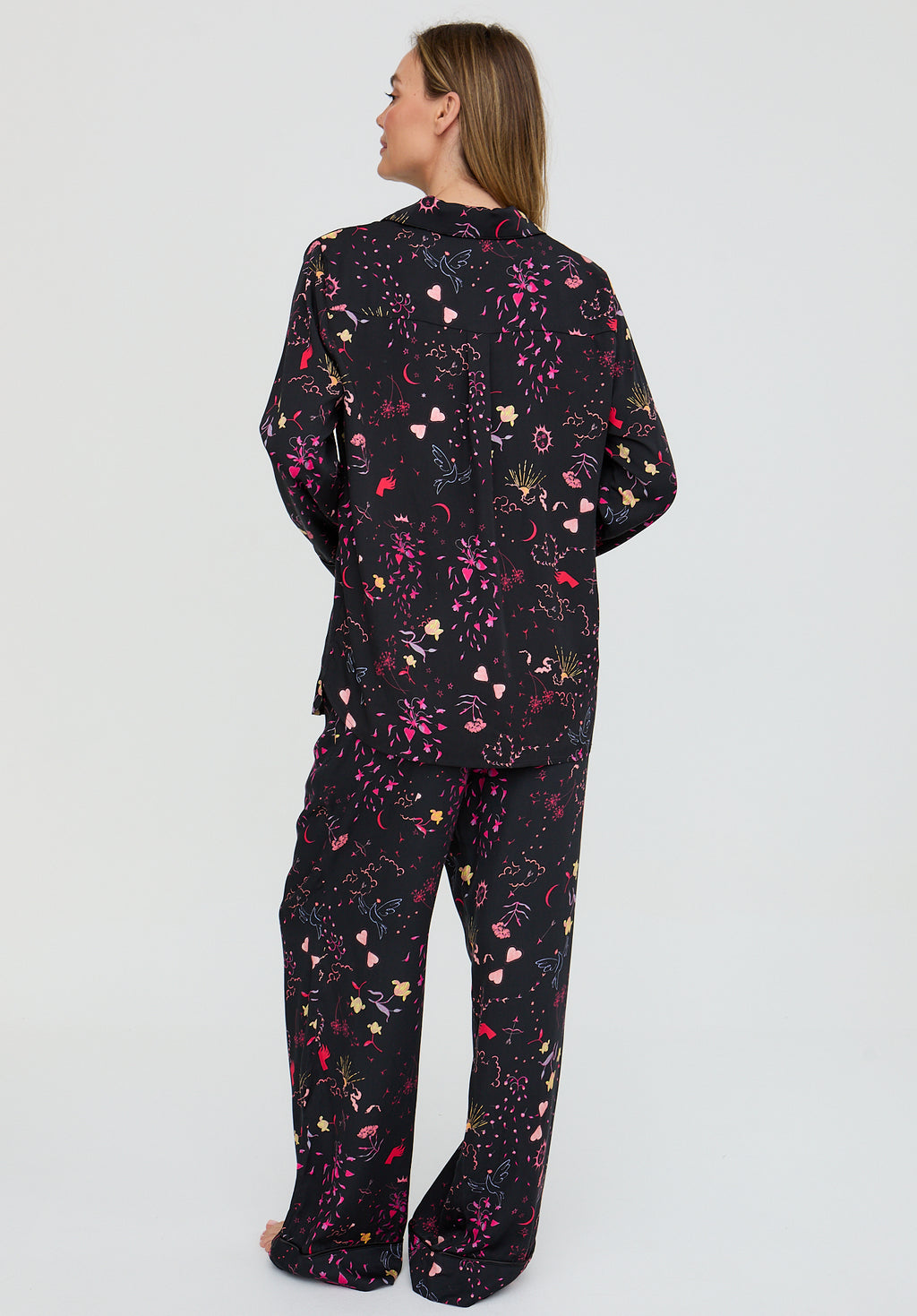 Person wearing a black floral patterned outfit on a light gray background