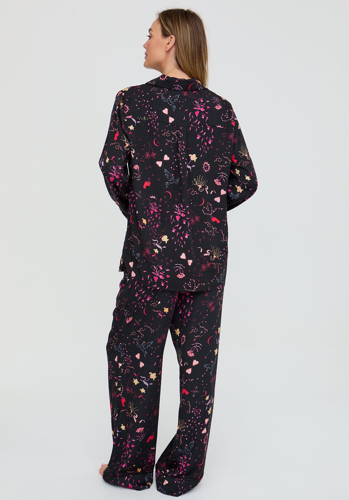 Person wearing a black floral patterned outfit on a light gray background