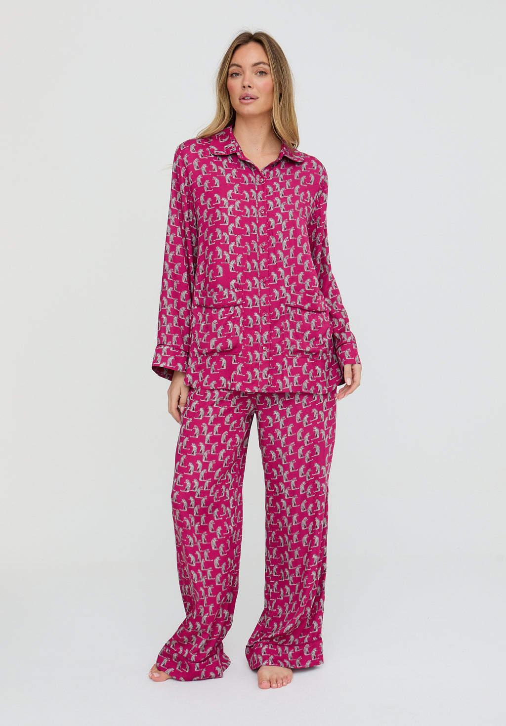 Woman wearing a pink patterned pajama set on a white background