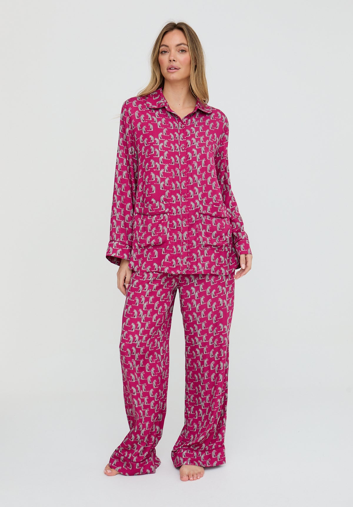 Woman wearing a pink patterned pajama set on a white background