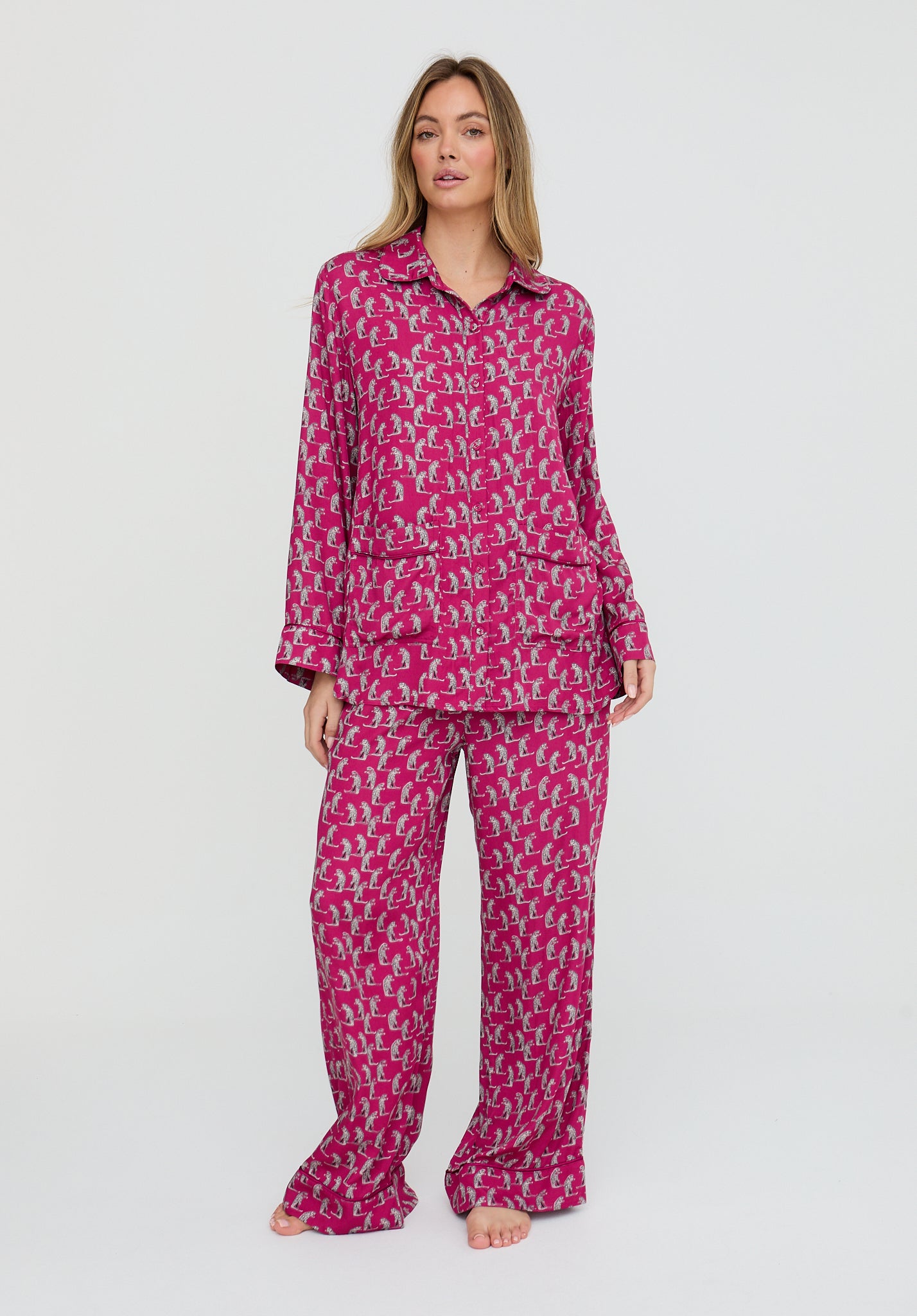 Woman wearing a pink patterned pajama set on a white background