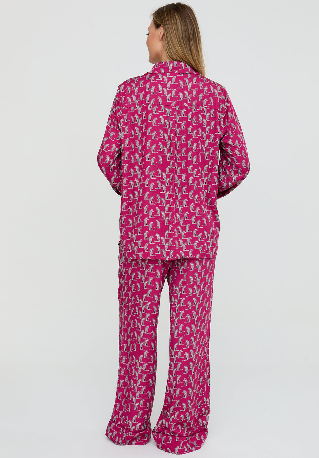 Person wearing a pink patterned pajama set on a white background