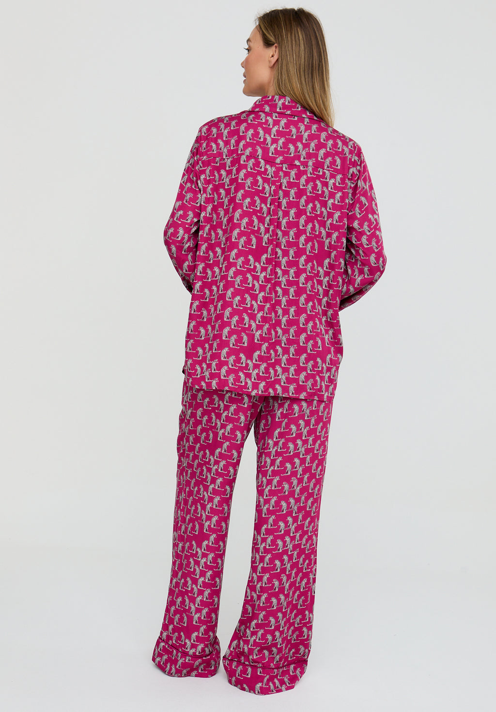 Person wearing a pink patterned pajama set on a white background