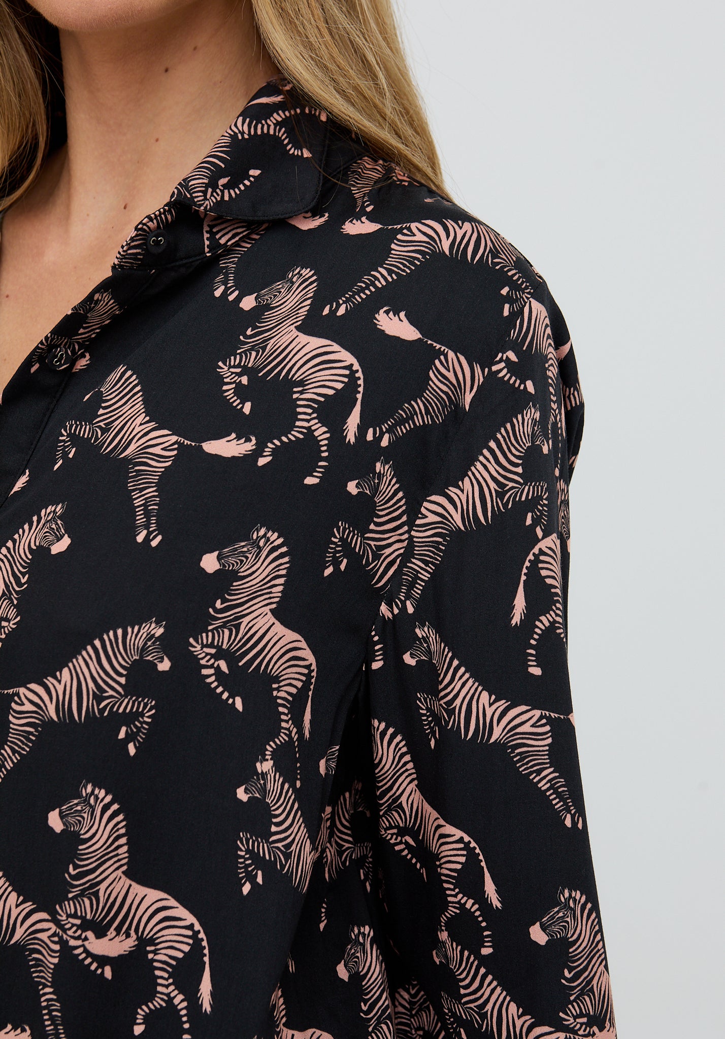 Black shirt with zebra pattern worn by a person on a light gray background