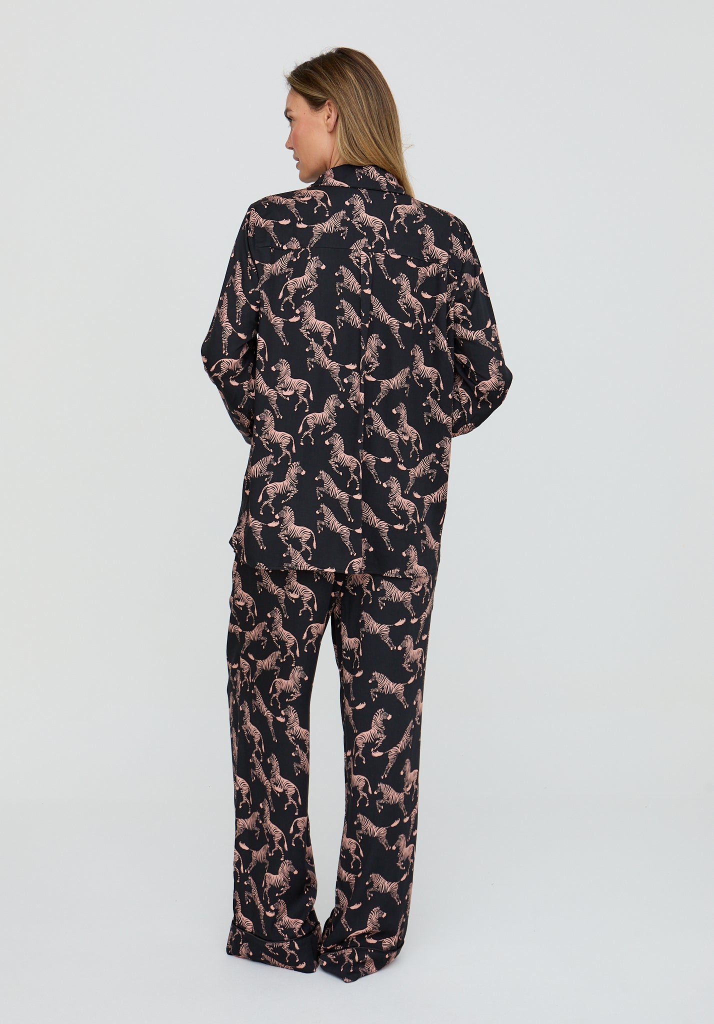 Person wearing a black and pink patterned outfit on a white background