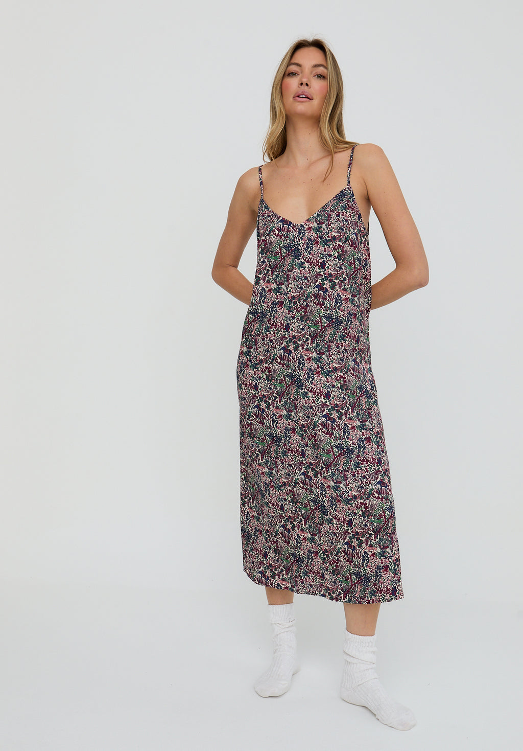 Woman wearing a floral slip dress on a white background