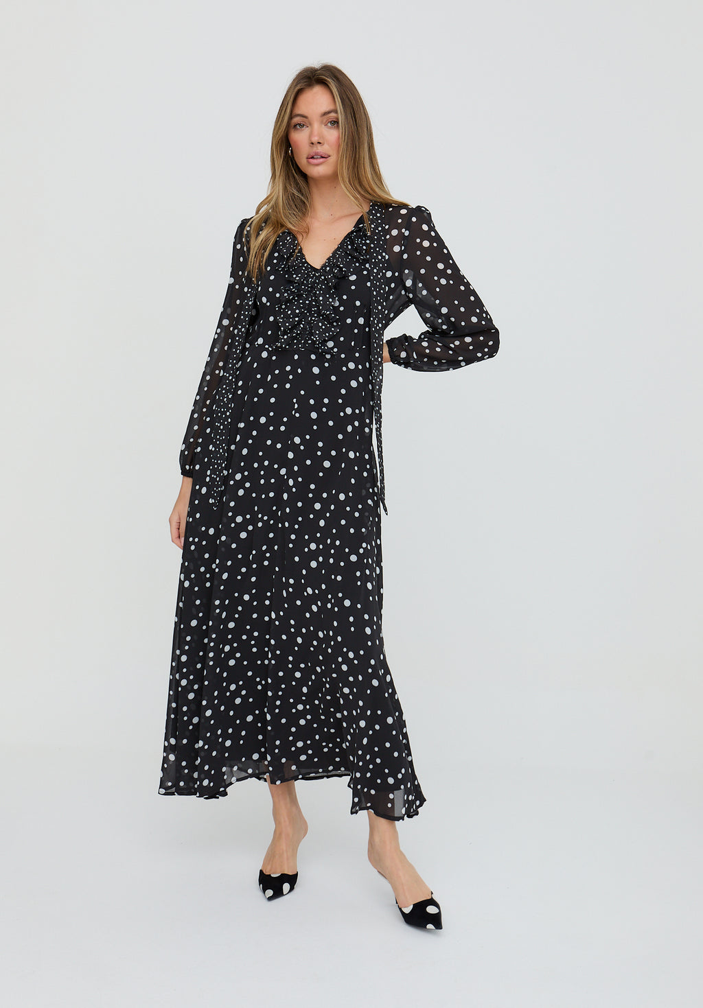 Woman wearing a black dress with white patterns on a white background