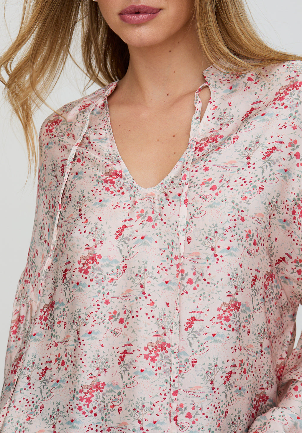 Floral patterned blouse worn by a person on a white background
