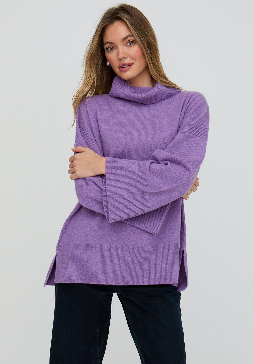 Woman wearing a purple sweater against a white background