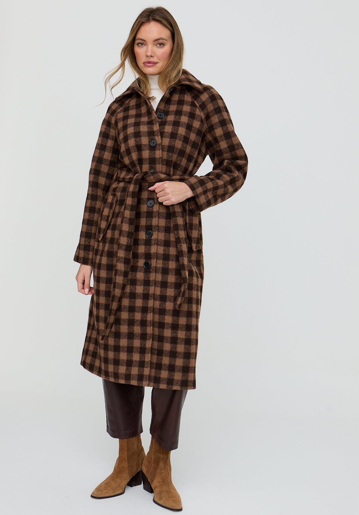 Woman wearing a brown checkered coat on a white background