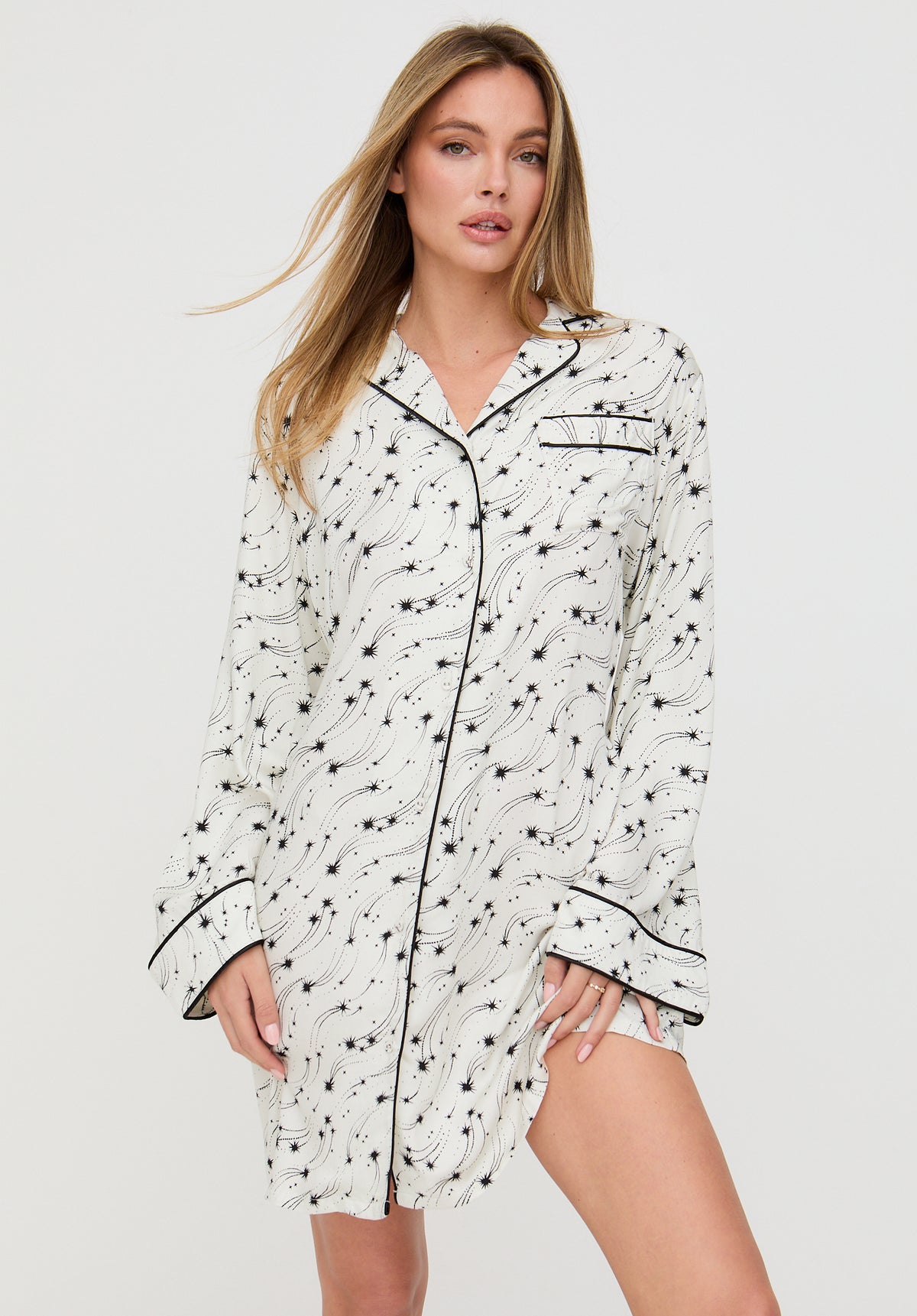 Woman wearing a white nightshirt with black patterns on a white background