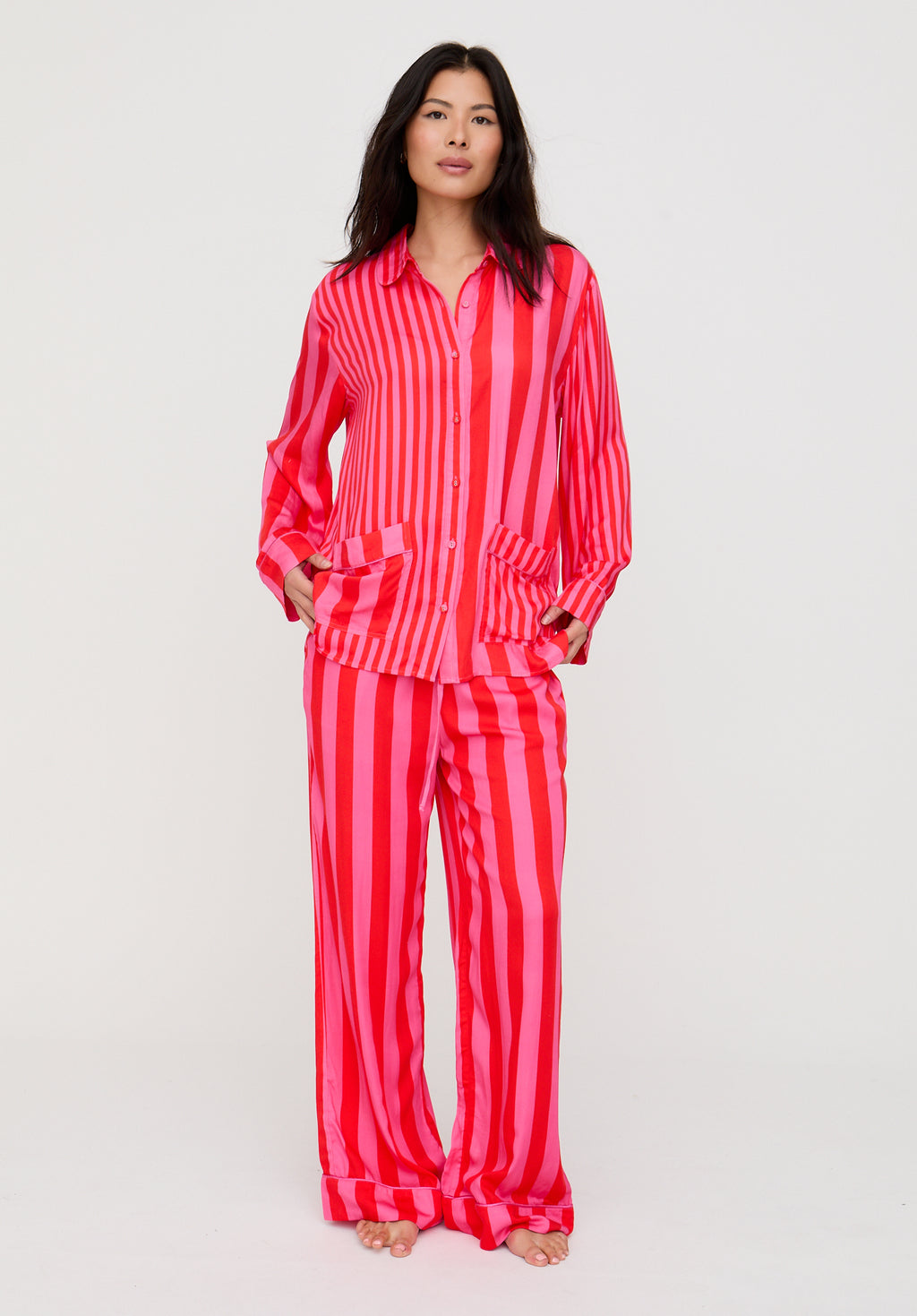 Woman wearing a red and white striped pajama set on a light gray background